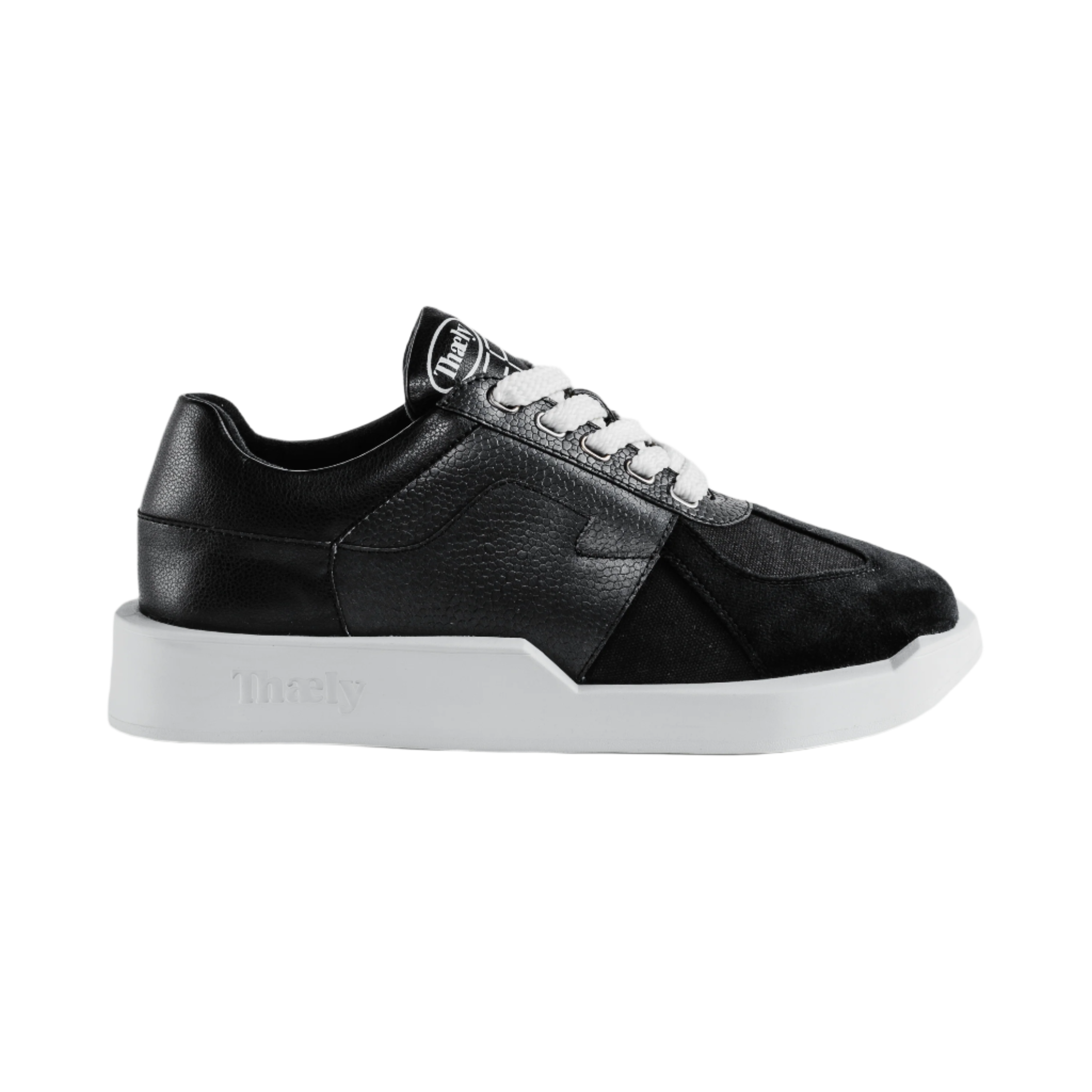 Black luxury streetwear sneaker with white sole and laces, side profile, isolated background