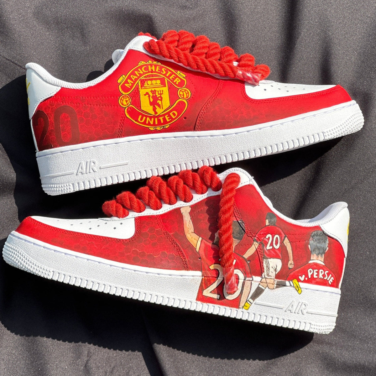 Custom red sneakers featuring Manchester United logo and soccer player artwork with bold red laces.