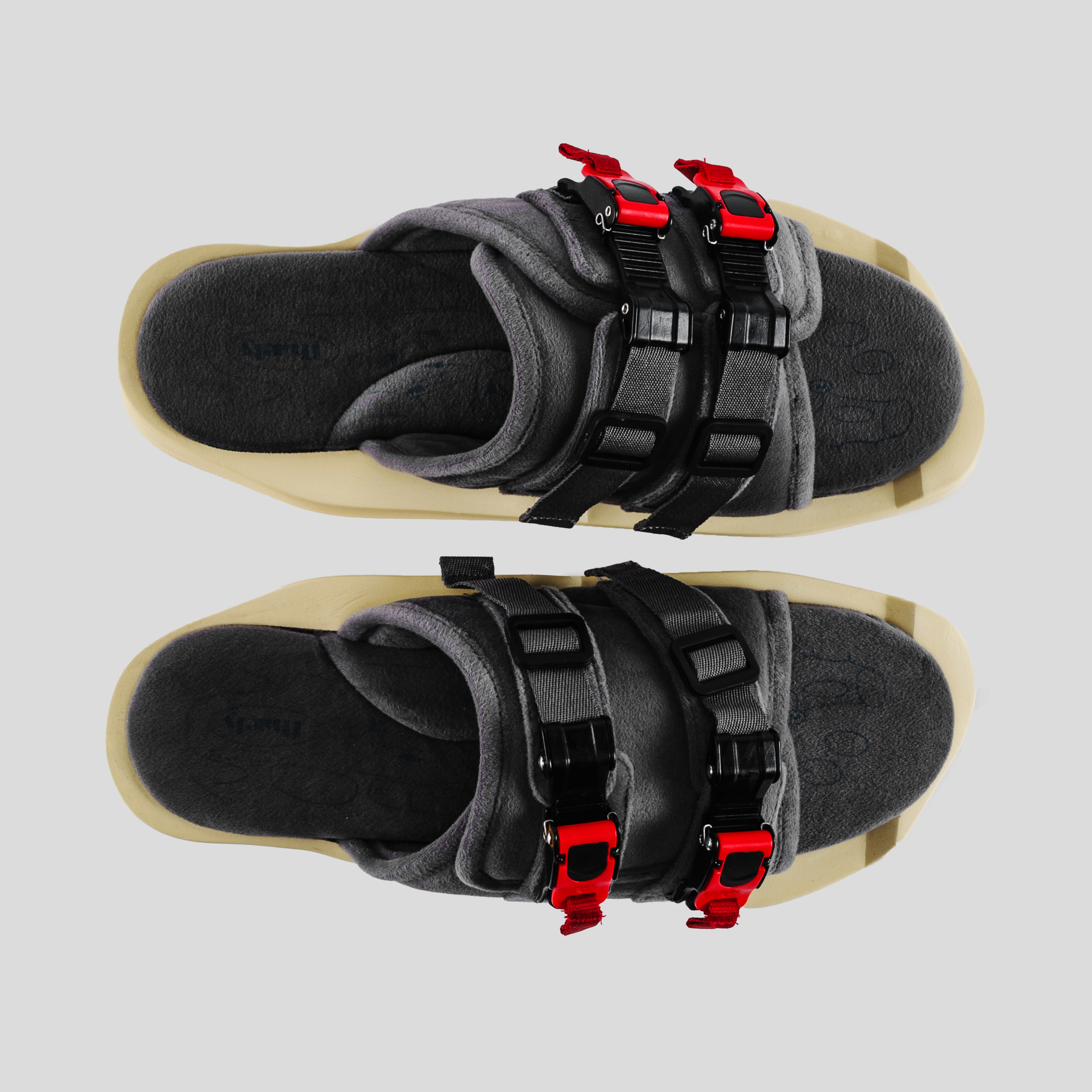 Grey streetwear sandals with black straps and red buckles, top view, beige sole.