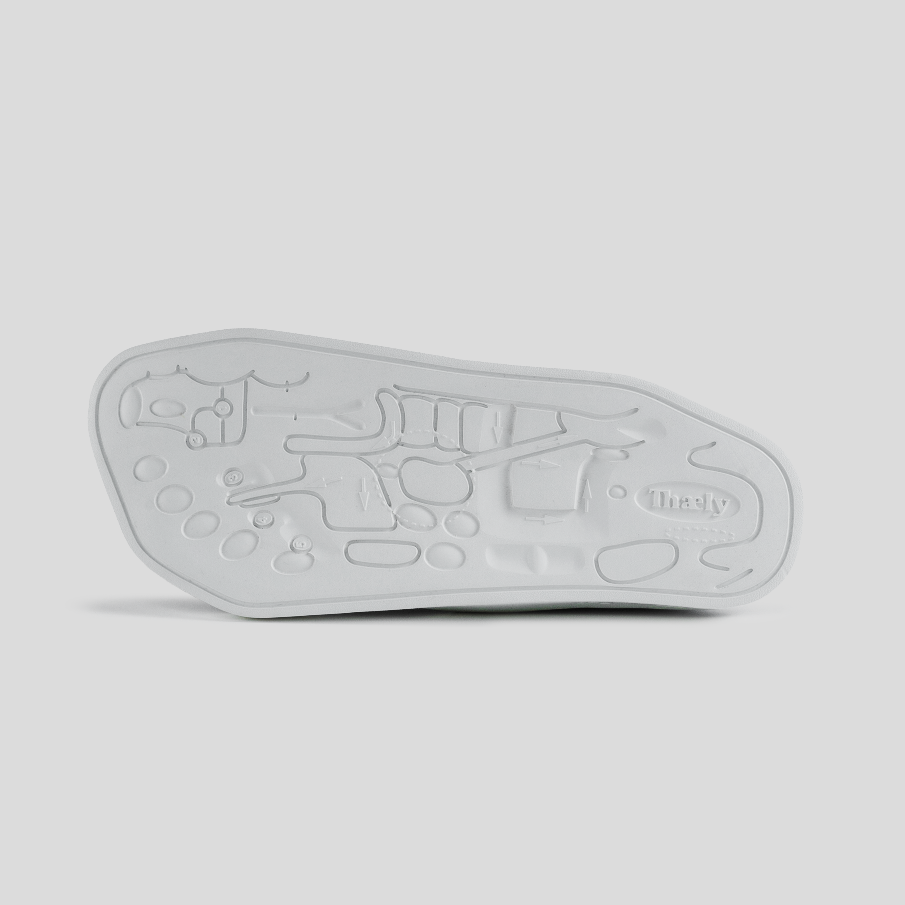 White sneaker sole with embossed anatomical foot diagram and textured grip pattern