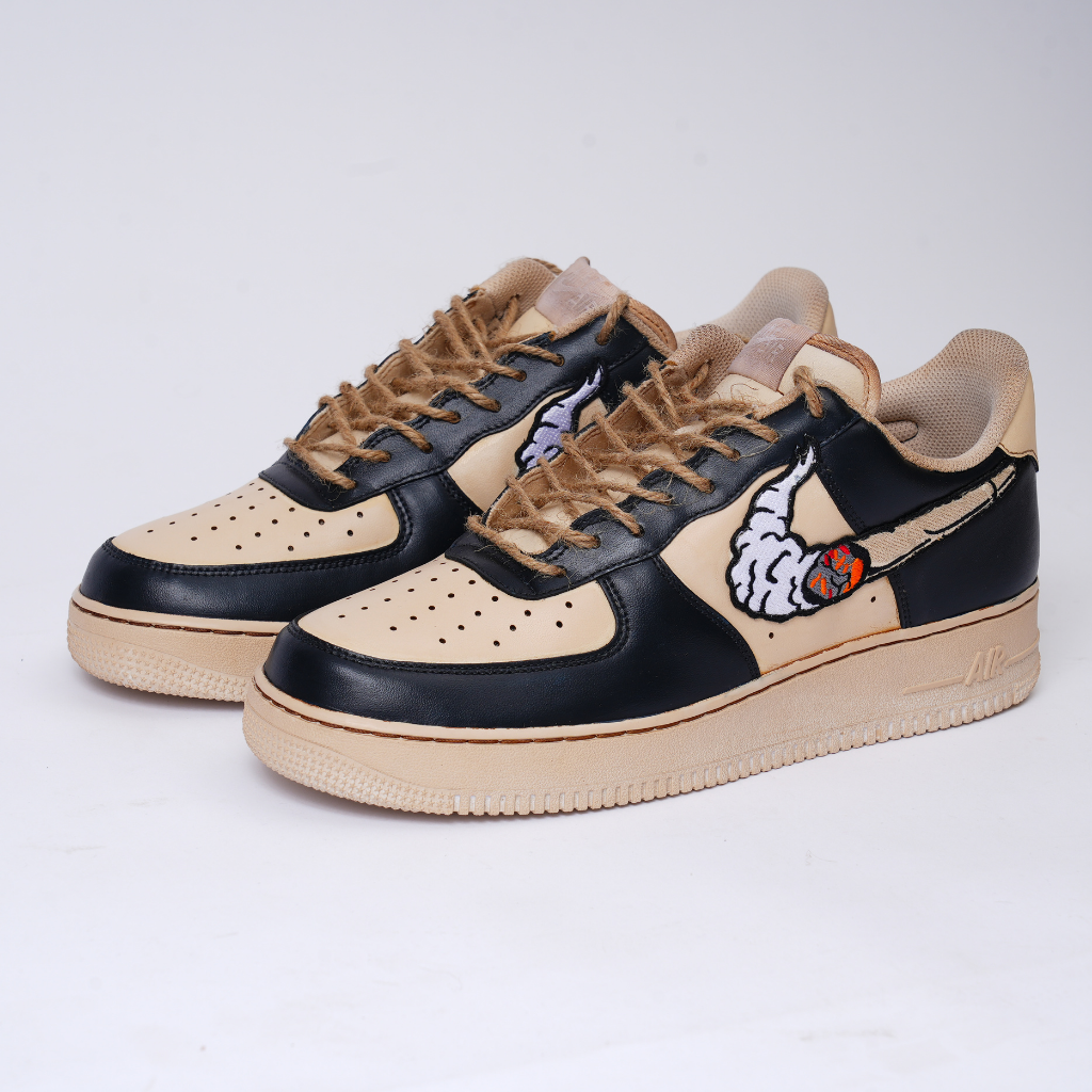 Tan and black streetwear sneakers with cartoon embroidered swoosh design, side view