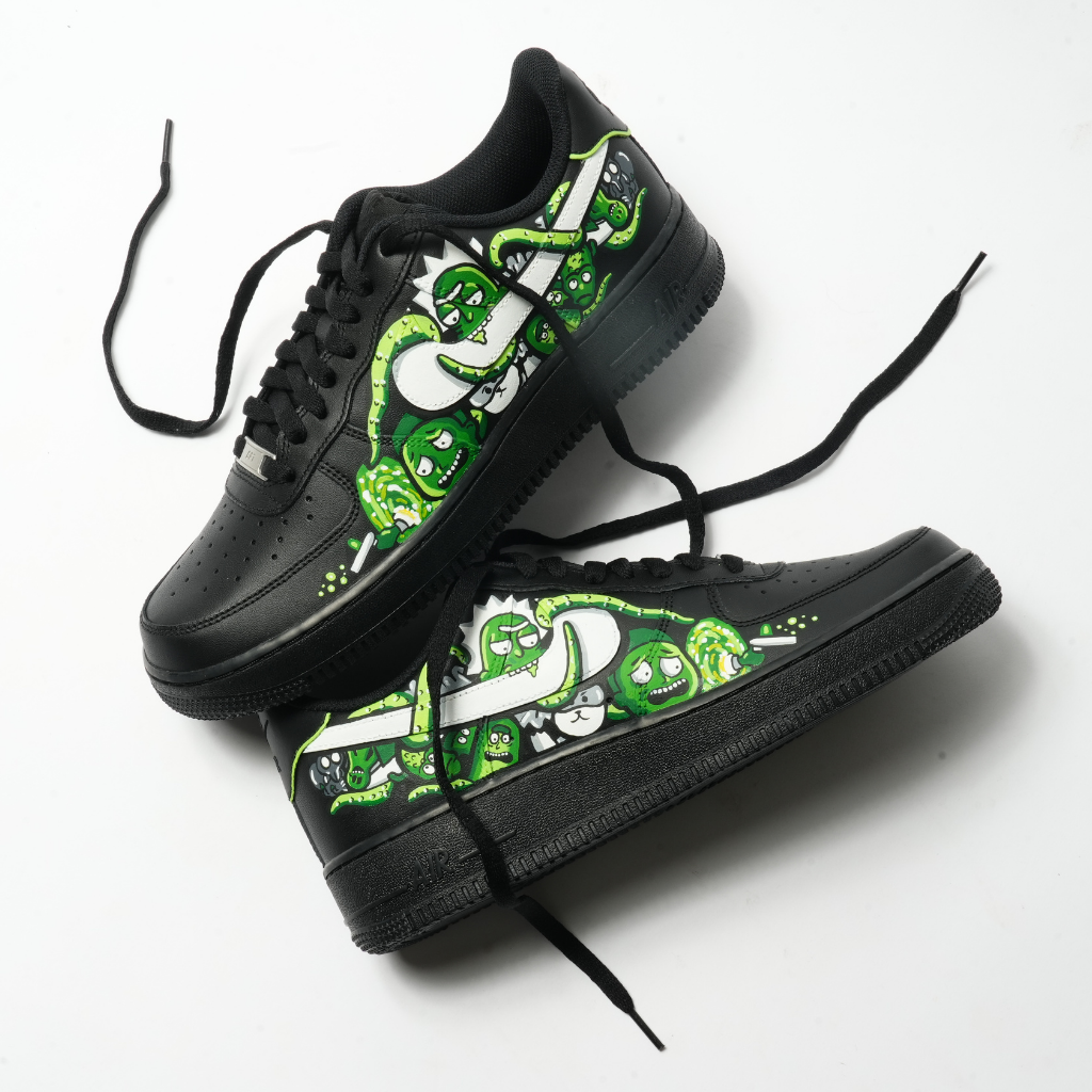 Black streetwear sneakers with green cartoon graphic art, designer footwear on white background