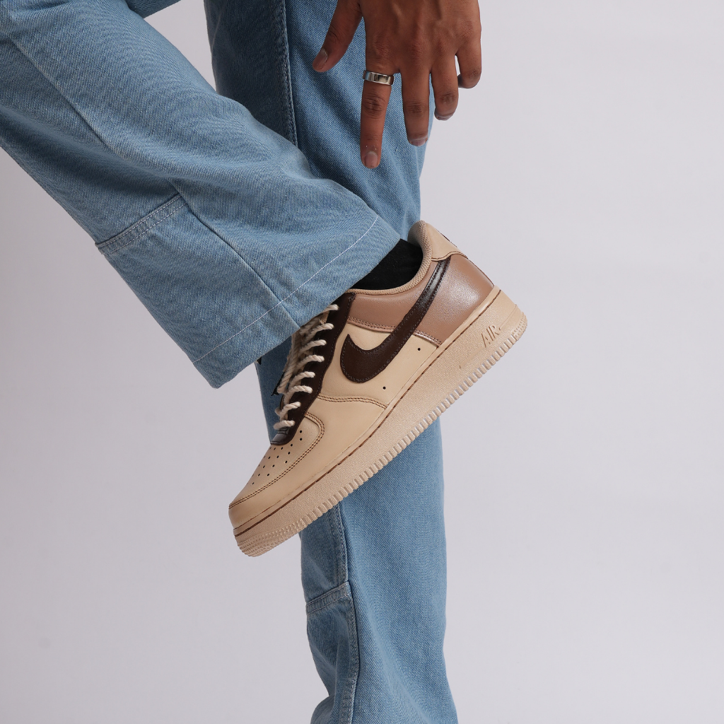 Beige and brown Nike Air Force 1 sneaker paired with light blue jeans streetwear