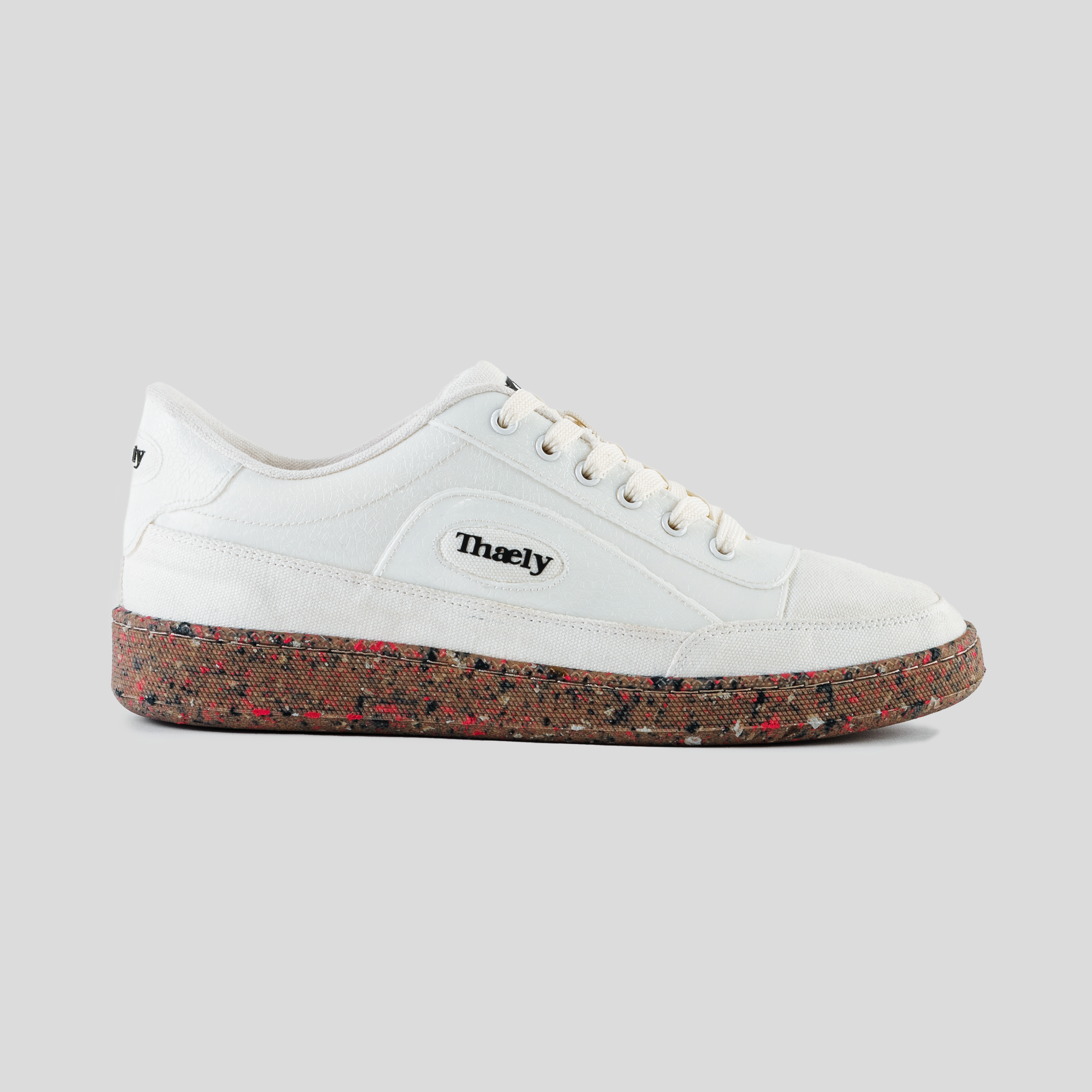 White streetwear sneaker with recycled speckled sole and Thaely logo on the side