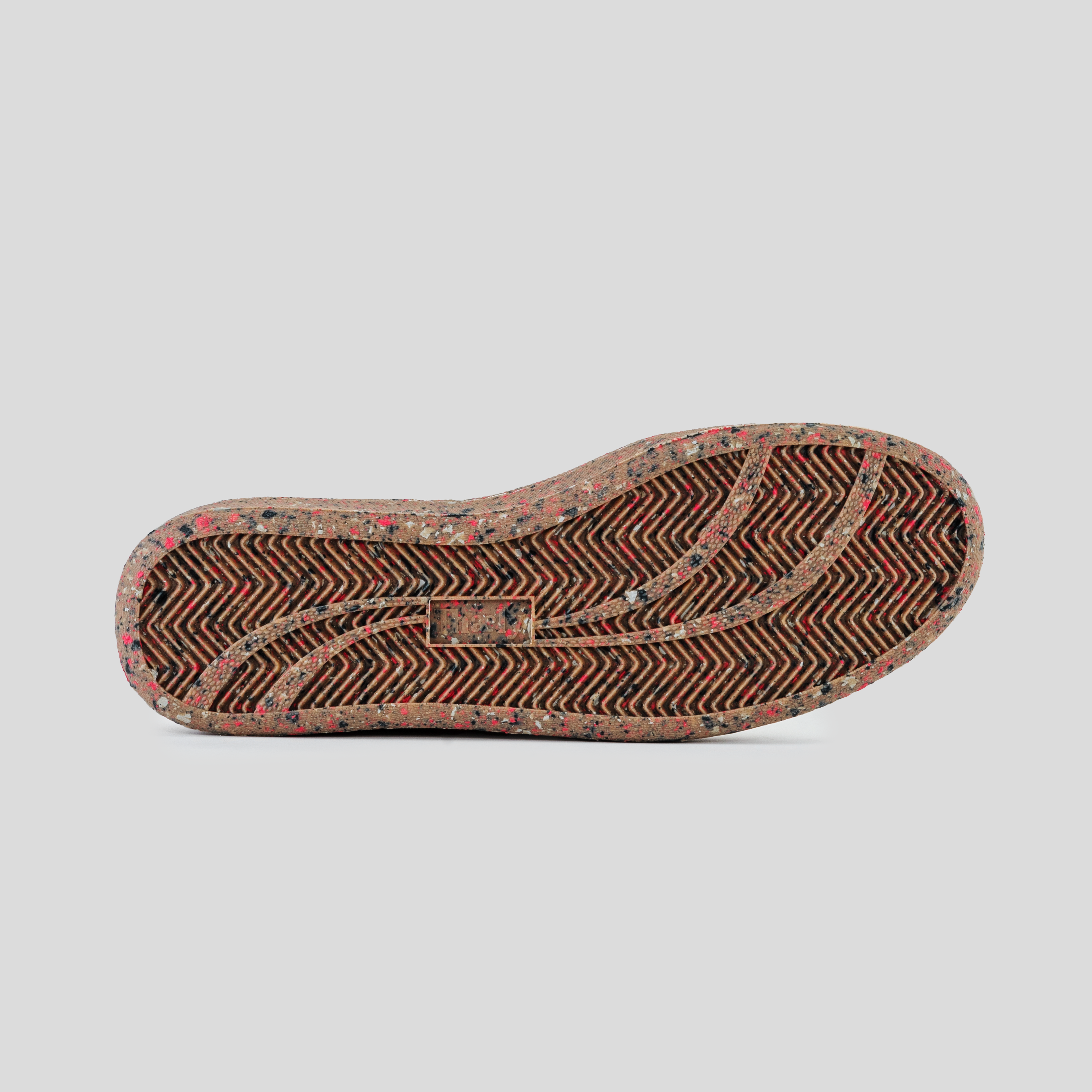 Speckled rubber sneaker outsole with herringbone tread pattern on a white background