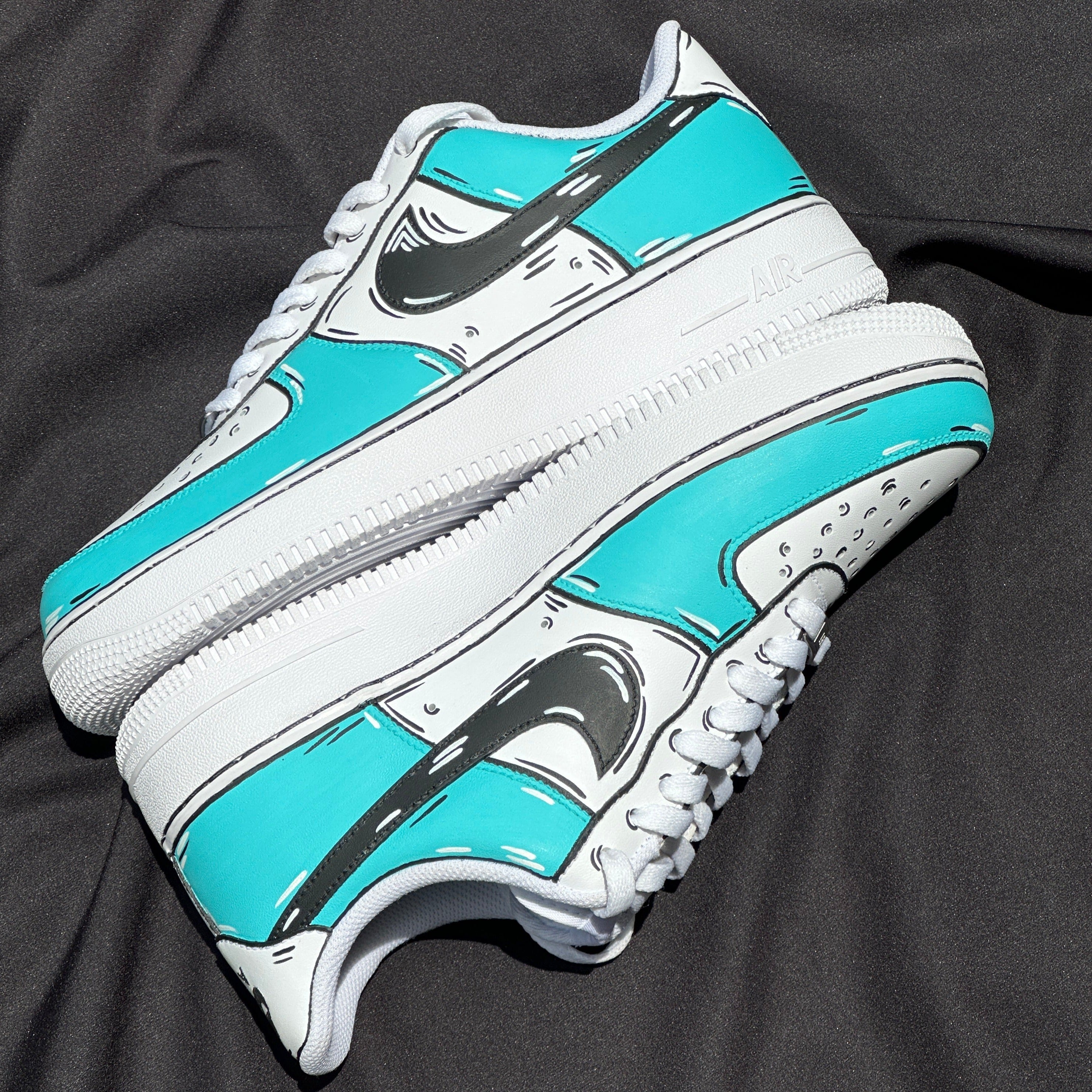 White and turquoise streetwear sneakers with black accents on a black background