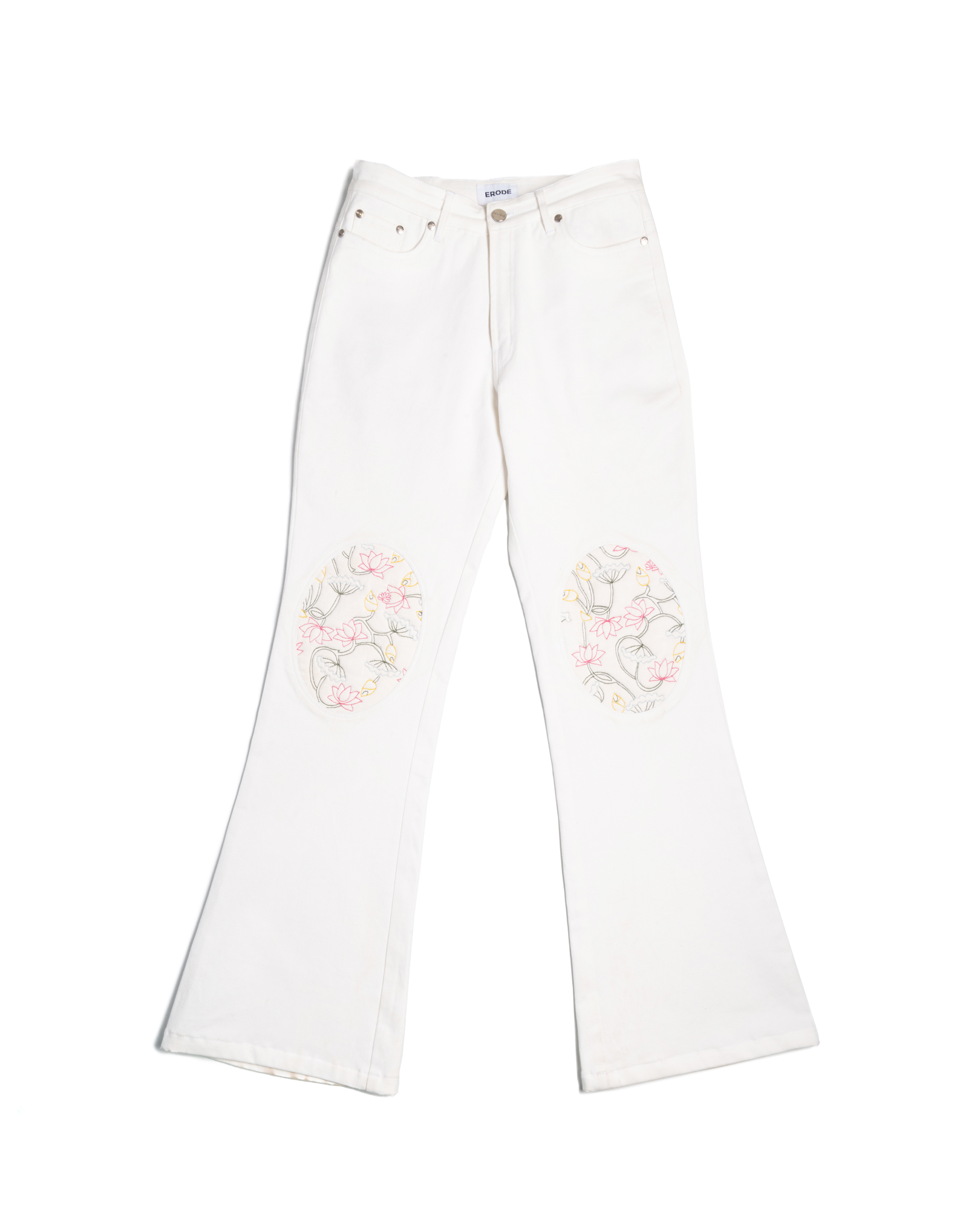White flared jeans with floral embroidery patches on knees, streetwear fashion style.