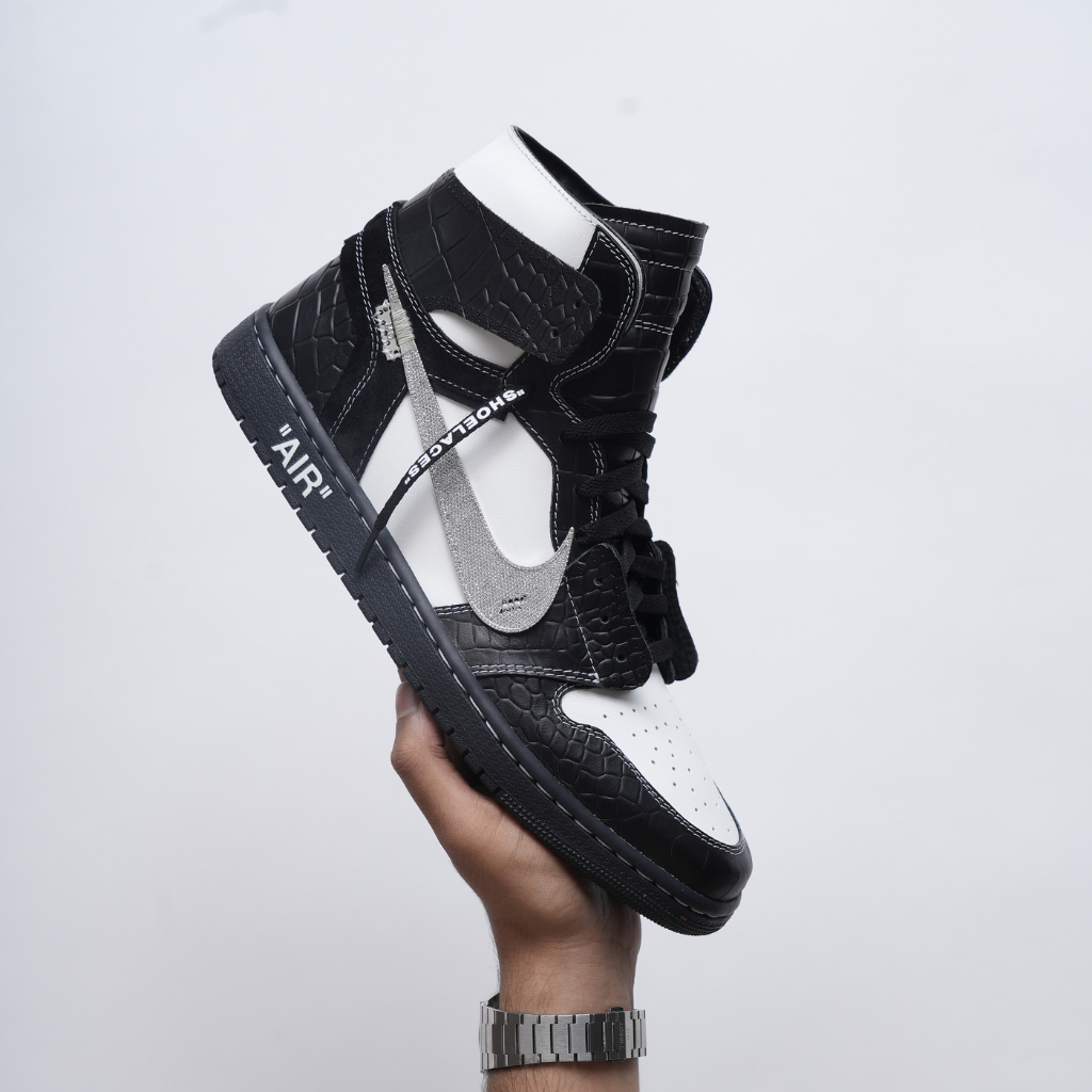 Black and white high-top sneaker with textured leather and metallic swoosh design