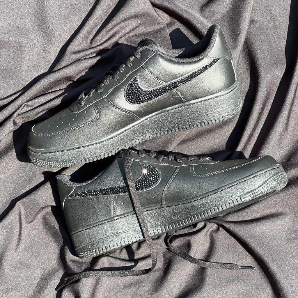Black leather streetwear sneakers with crystal Nike swoosh on satin background