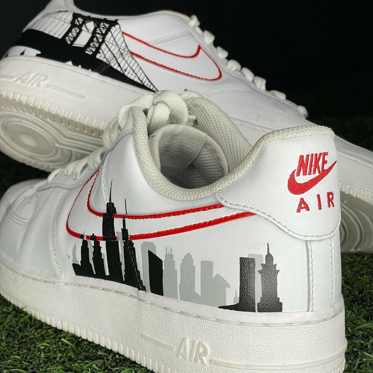 White Nike Air Force 1 sneakers with red swoosh, black city skyline and bridge graphic design