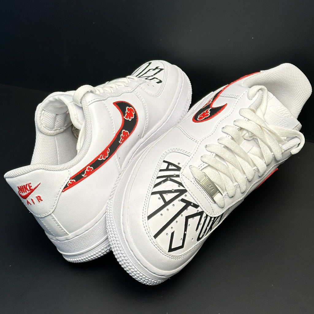 White Nike Air Force 1 sneakers with red cloud pattern Swoosh and AKATSUKI lettering, black background