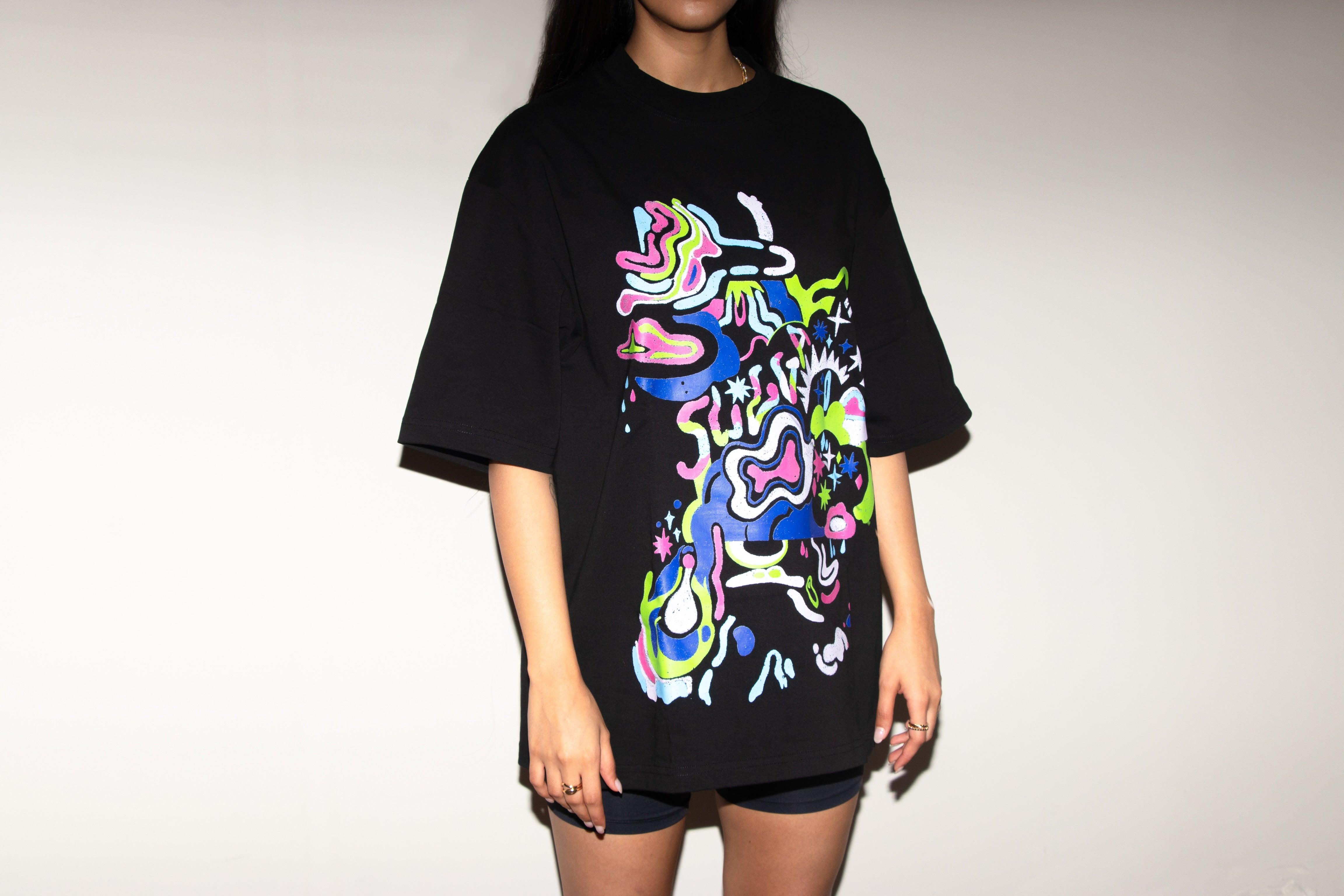 Oversized black streetwear t-shirt with colorful abstract graphic print, worn by a model