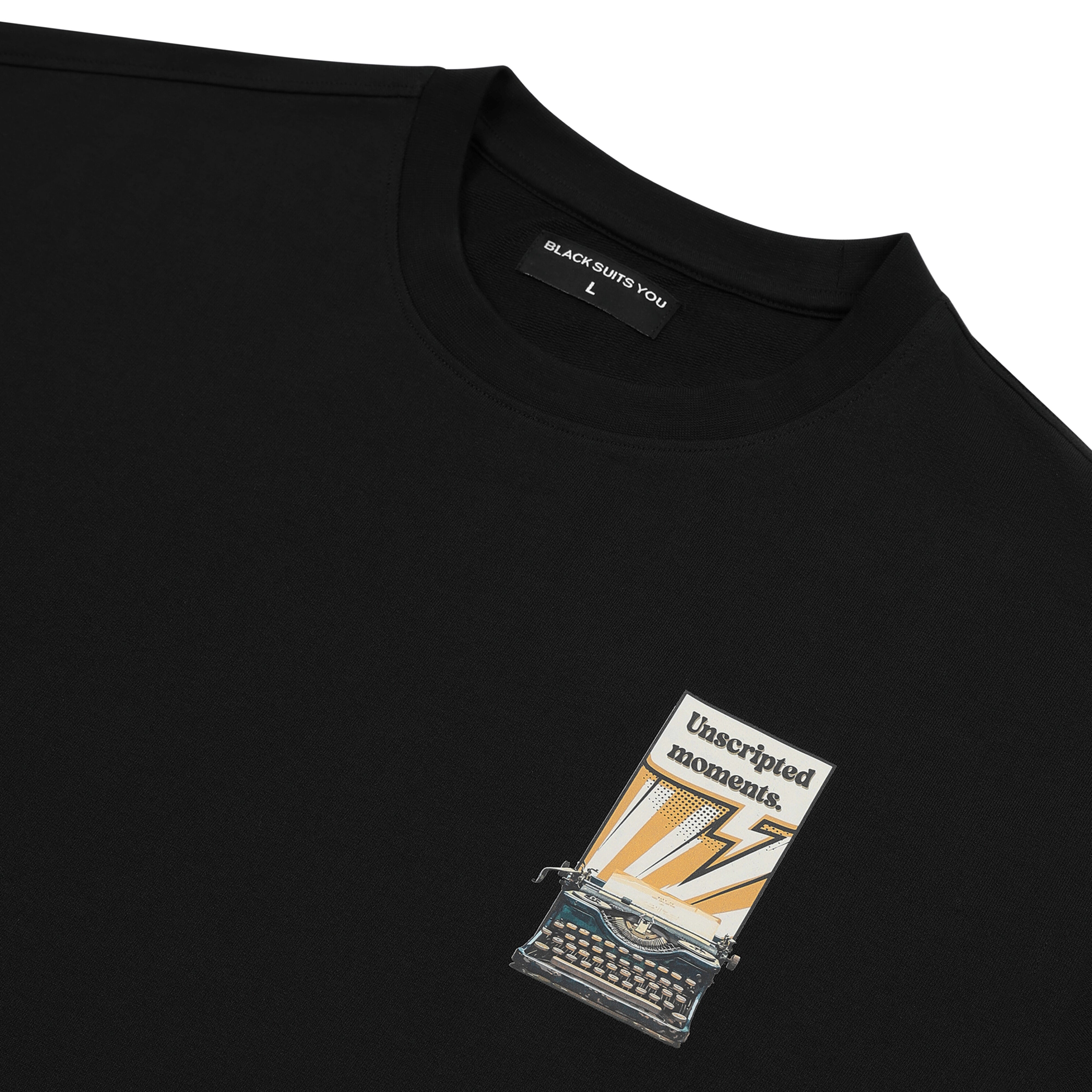 Black streetwear t-shirt with typewriter and 'Unscripted moments' graphic on chest