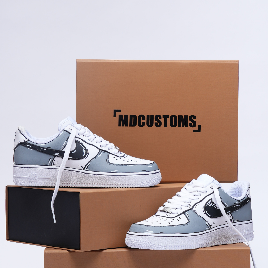 Custom white and gray streetwear sneakers with cartoon detailing displayed on shoeboxes