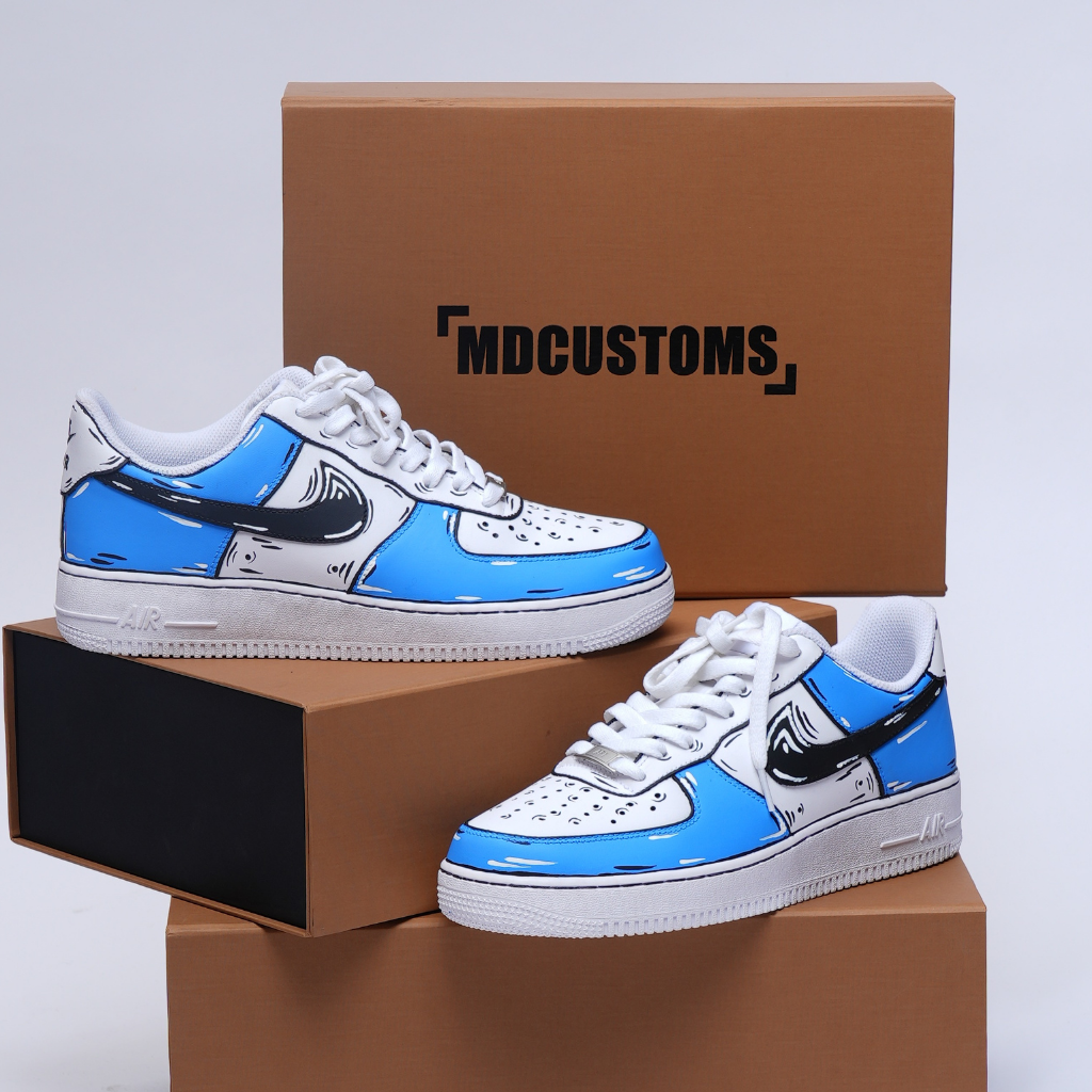 Custom blue and white streetwear sneakers with cartoon style detailing on display boxes