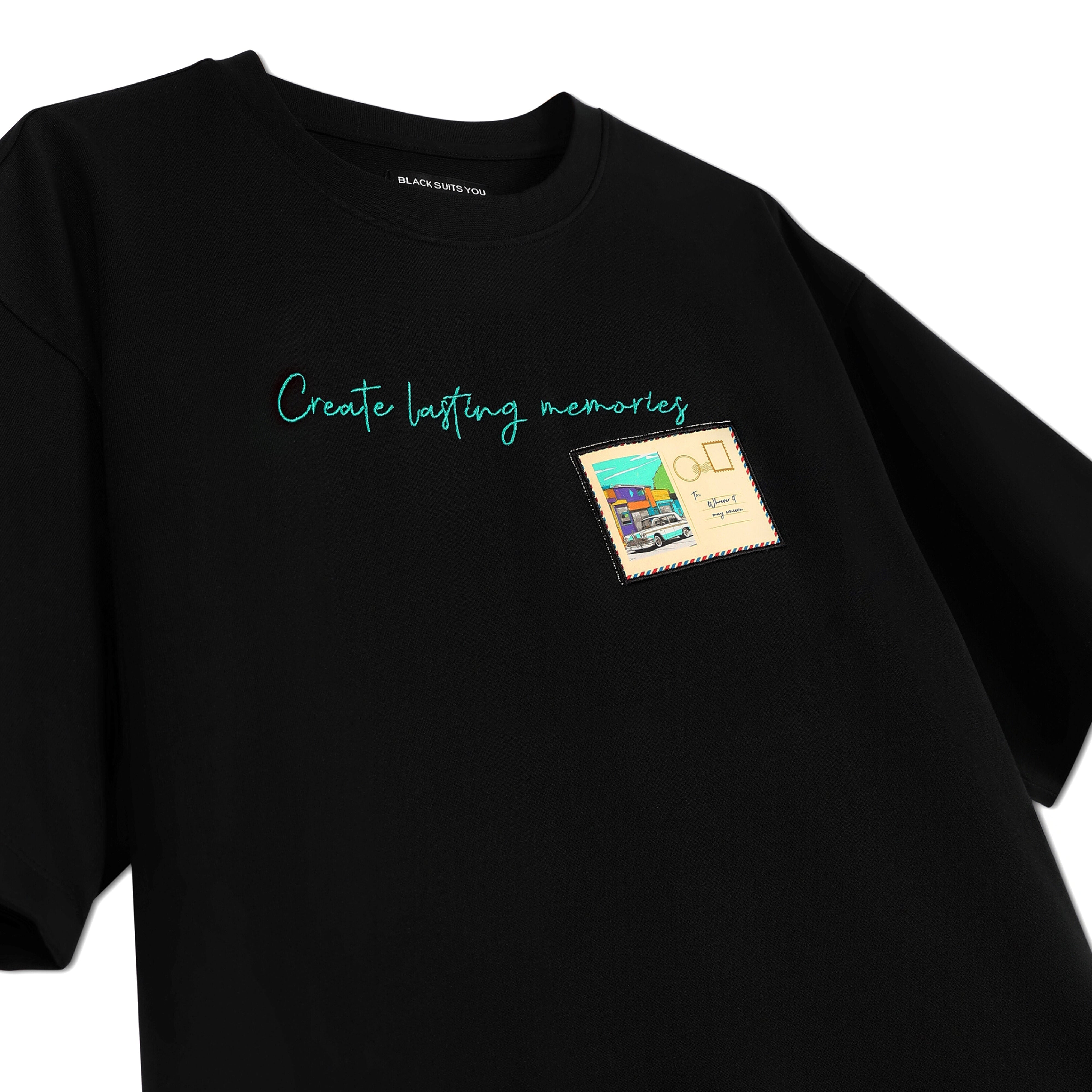 Black streetwear t-shirt with 'Create lasting memories' text and postcard graphic on chest
