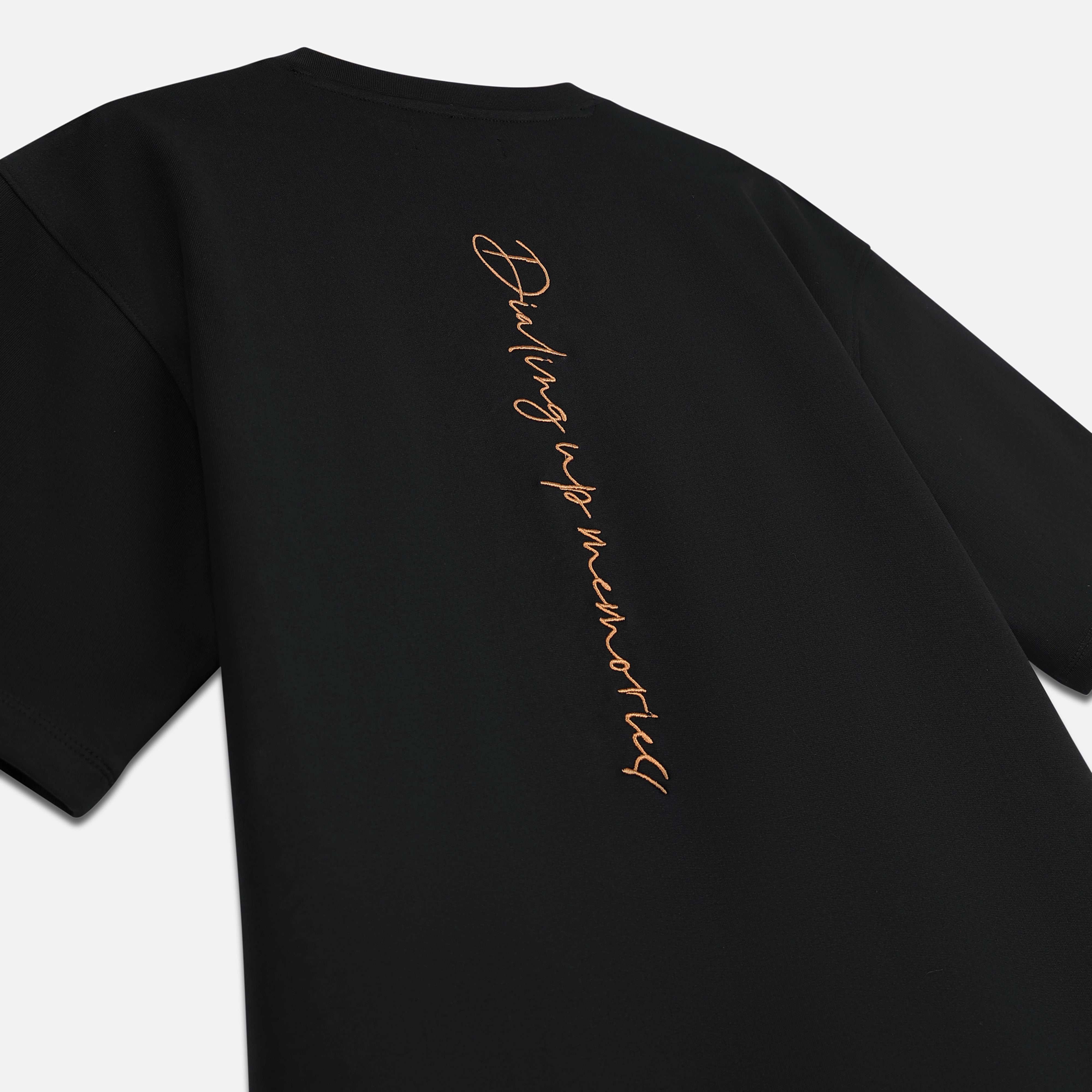 Black streetwear t-shirt with vertical orange script text 'Dialing up memories' on back