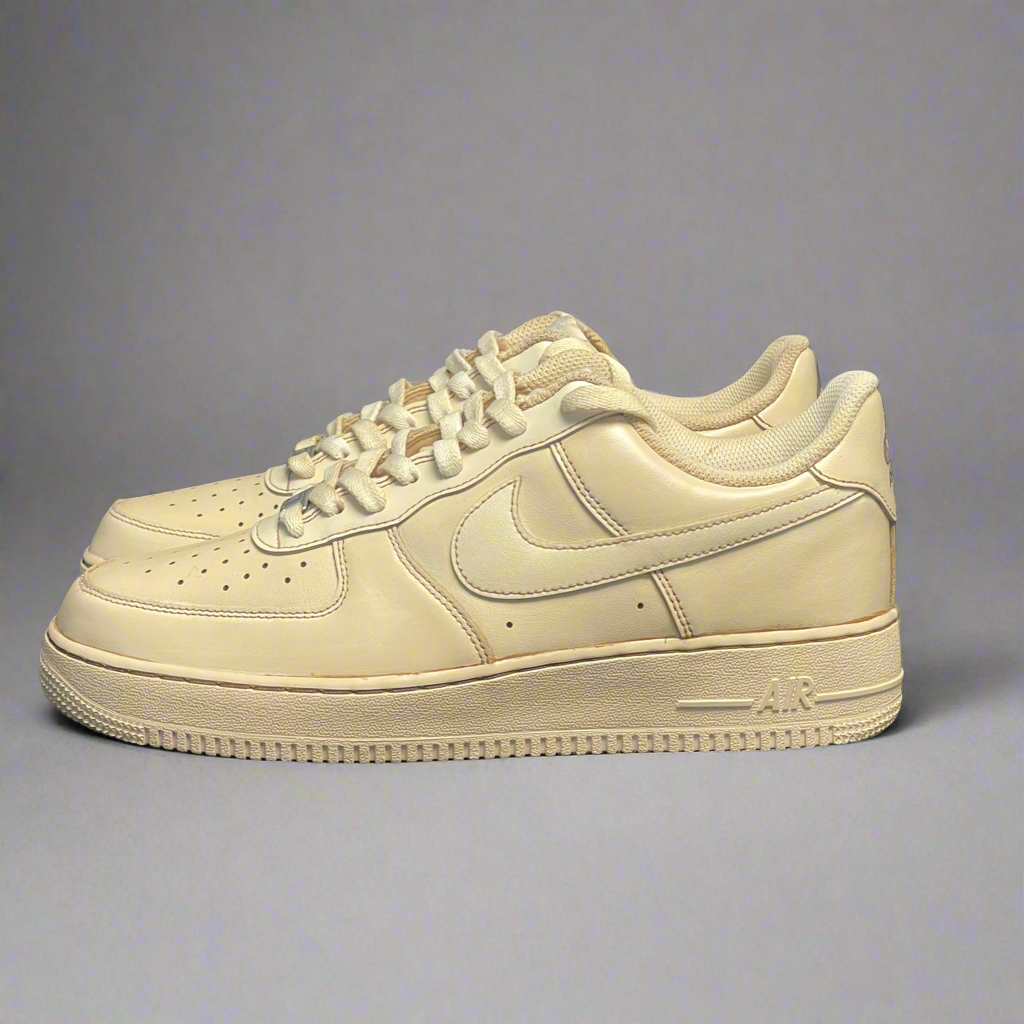 Beige leather streetwear sneakers with perforated toe box and textured sole on gray background