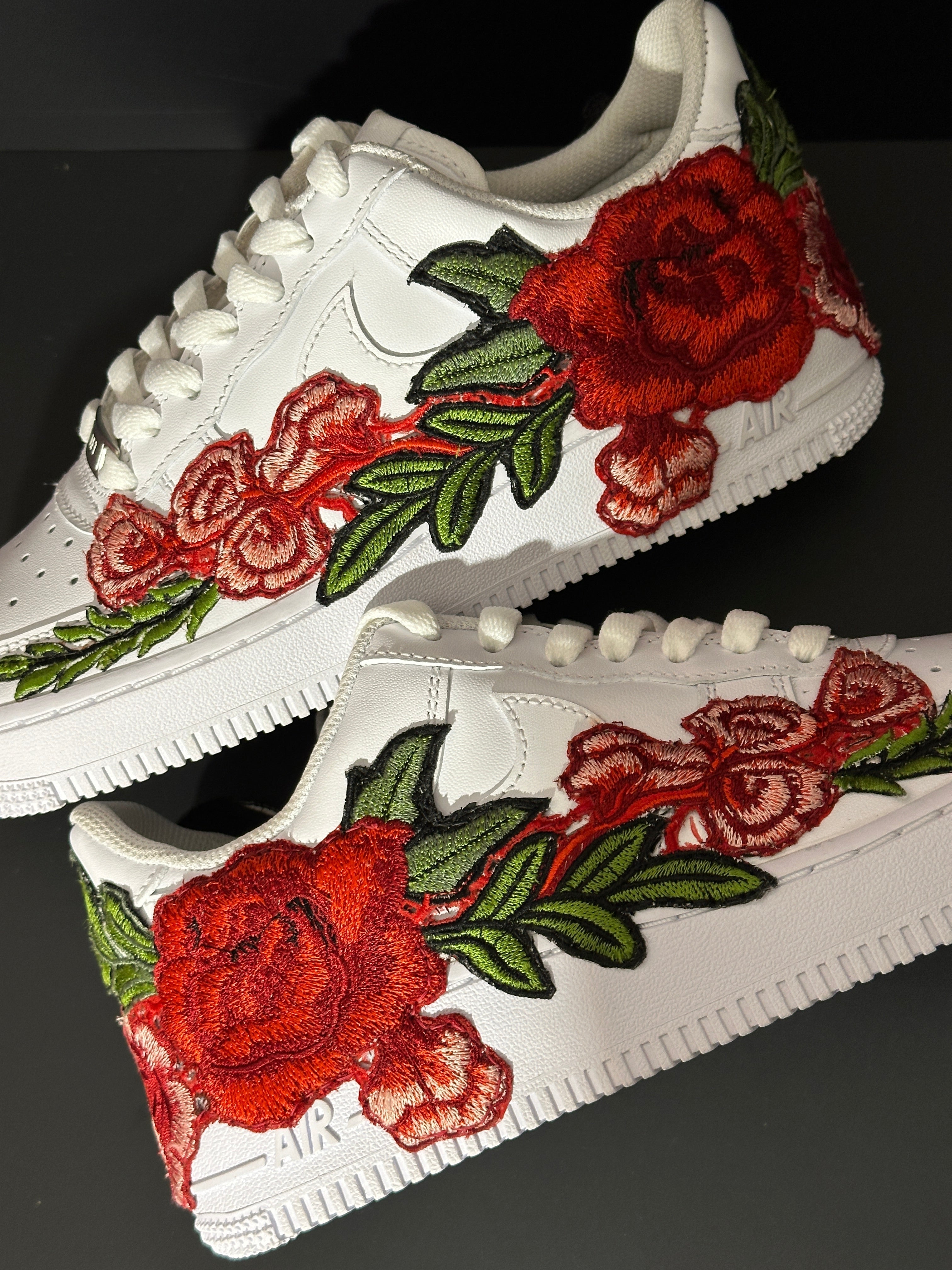 White streetwear sneakers with red rose floral embroidery and green leaves on black background