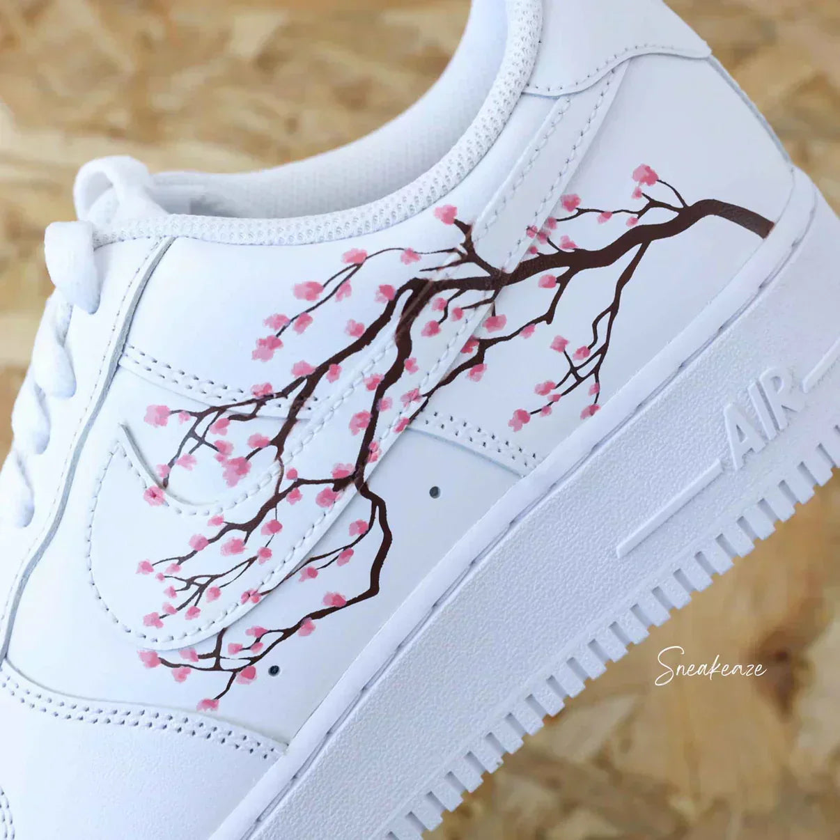 White sneaker with pink cherry blossom branch design, luxury streetwear style
