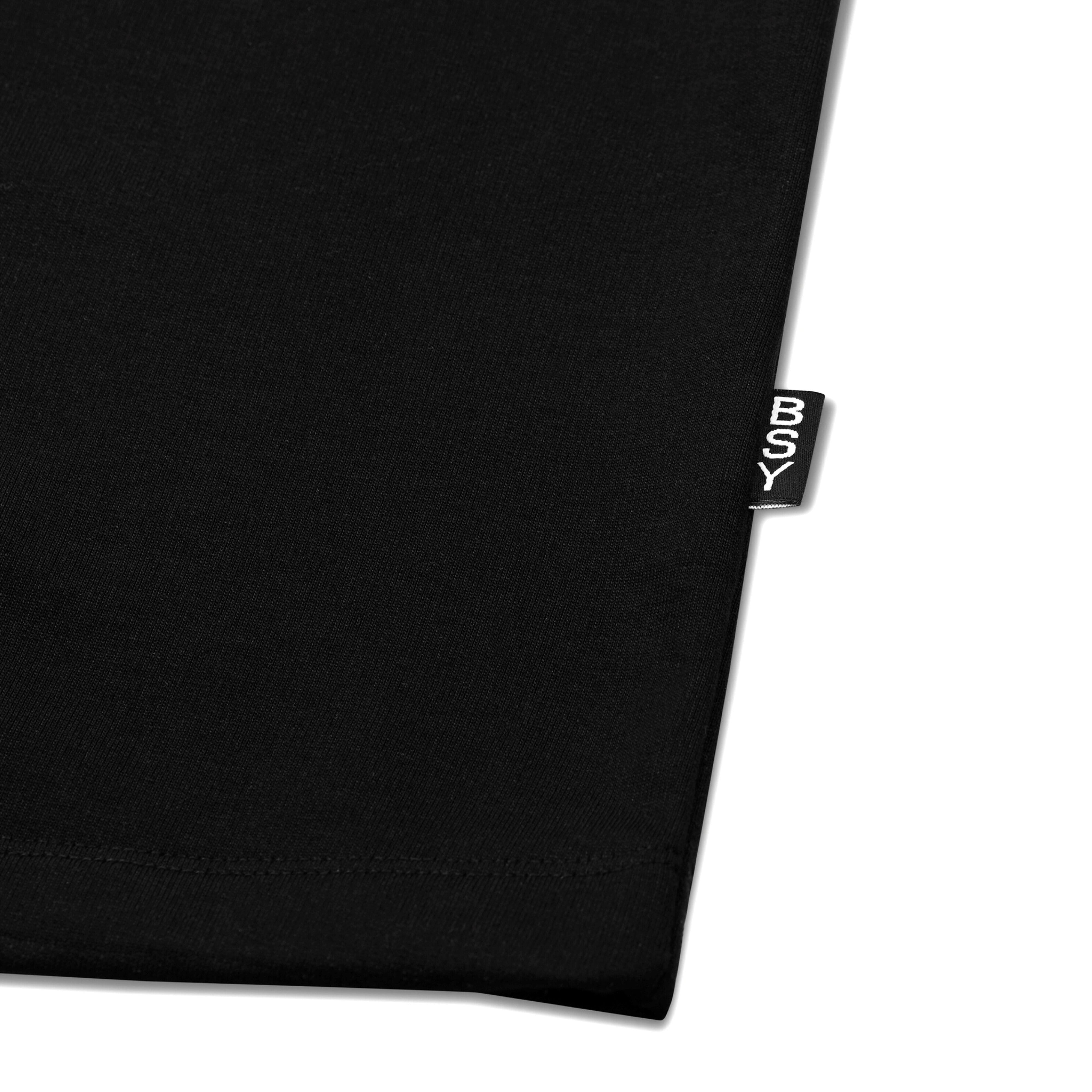 Close-up of a black streetwear t-shirt hem with BSY label on a white background