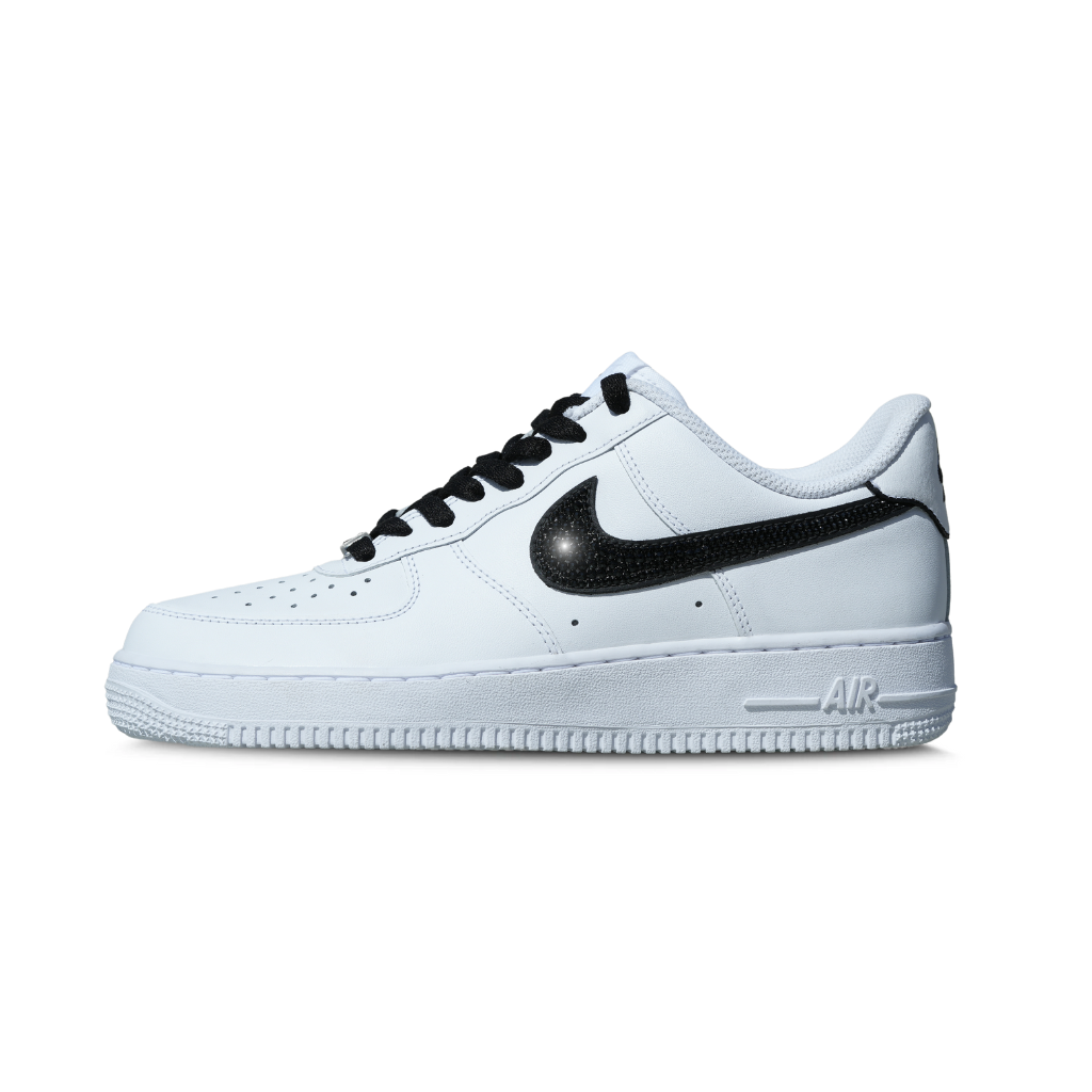 White low-top sneaker with black swoosh, black laces, and streetwear style on white background