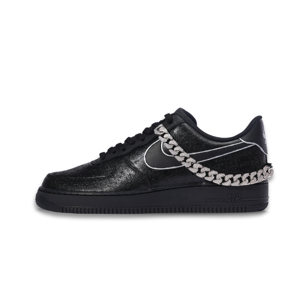 Black streetwear sneaker with metallic silver chain and white outlined details on white background
