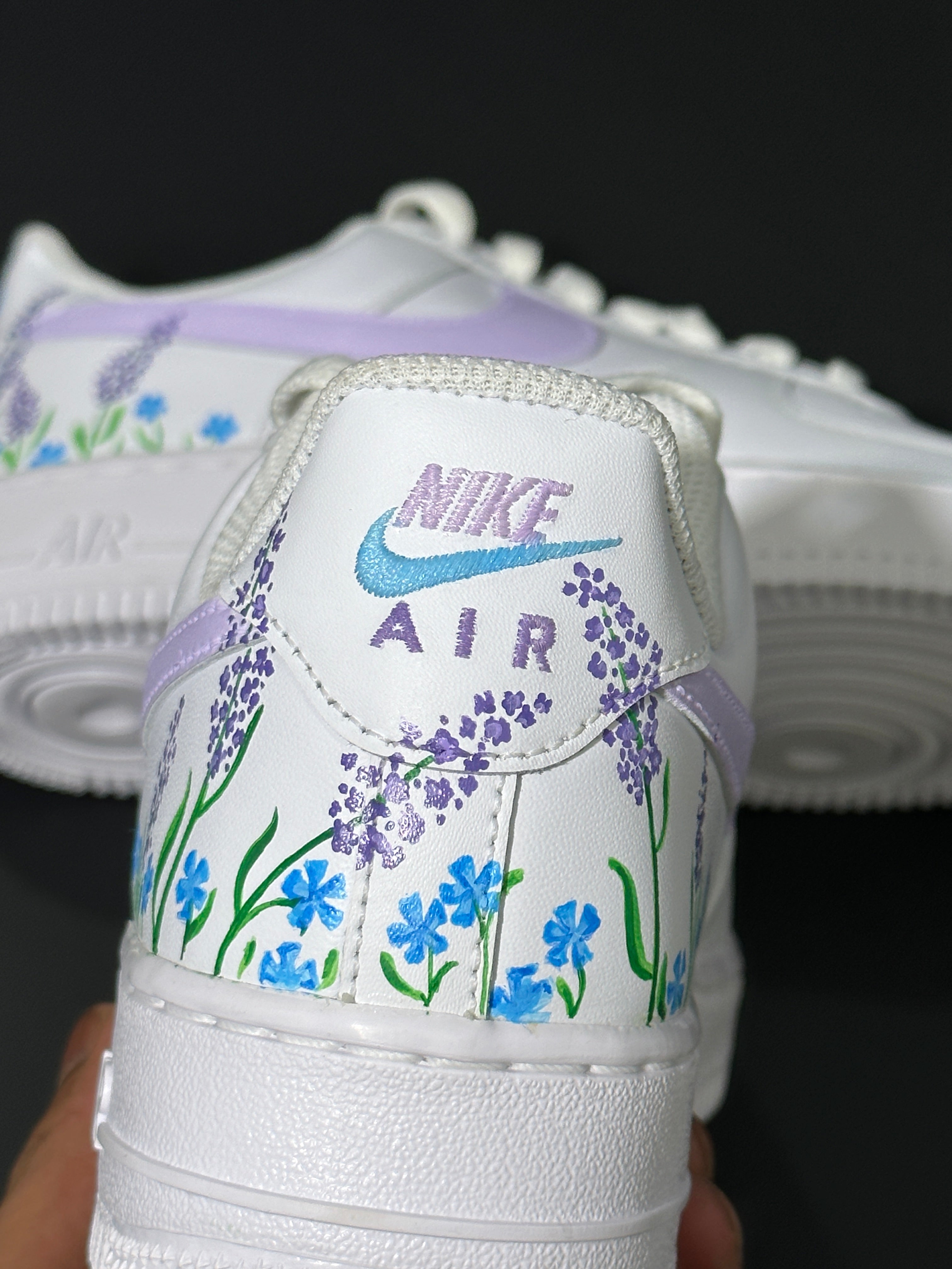 White Nike Air Force 1 sneaker with hand-painted lavender and blue floral design