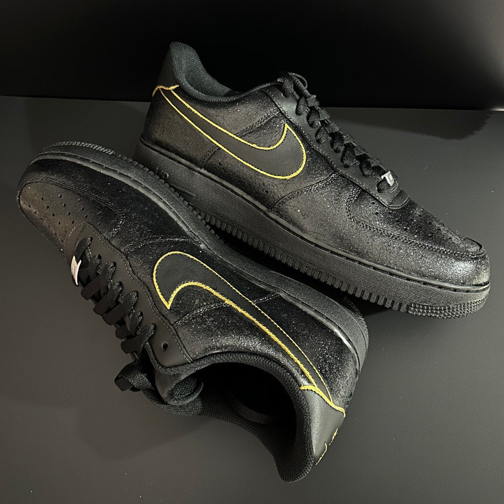 Black Nike sneakers with yellow outlined Swoosh, luxury footwear on dark background