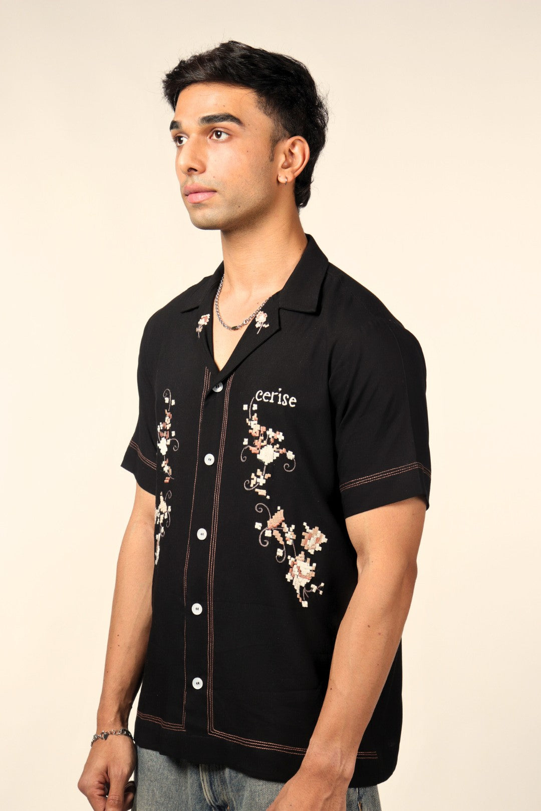 Man wearing black short-sleeve embroidered streetwear shirt with floral patterns