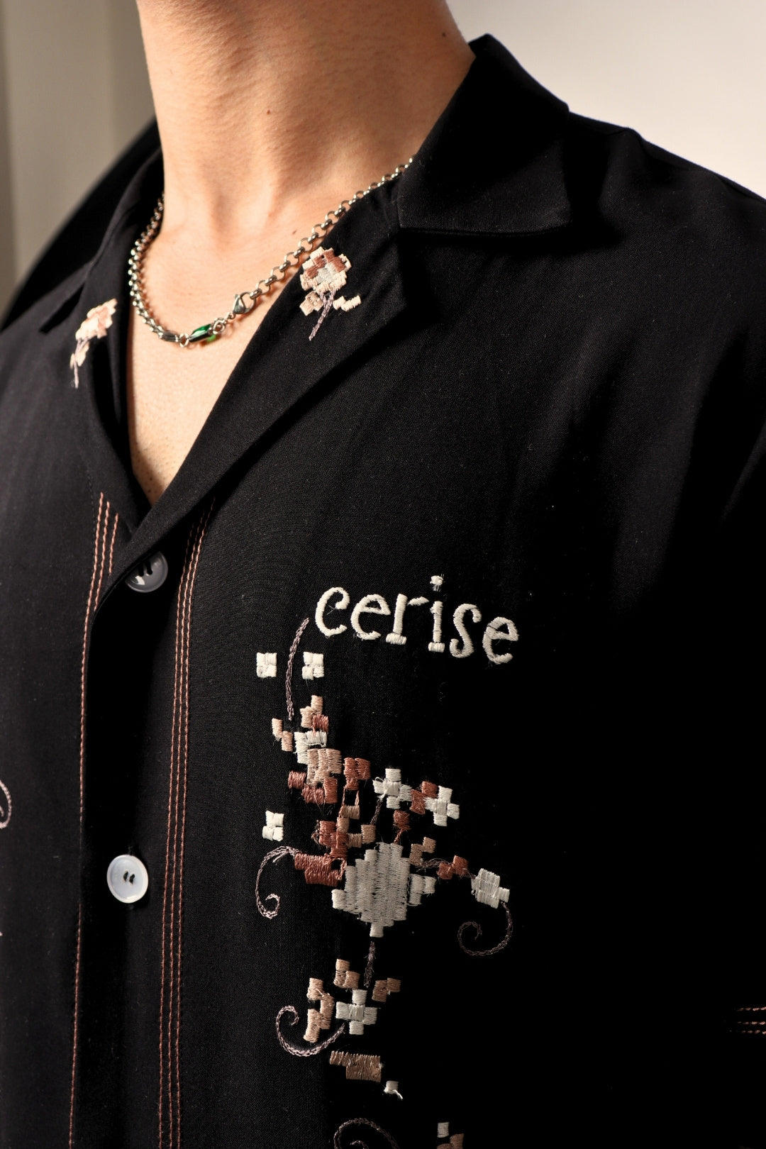 Black streetwear shirt with white and brown floral embroidery, pixel design, and 'cerise' text.