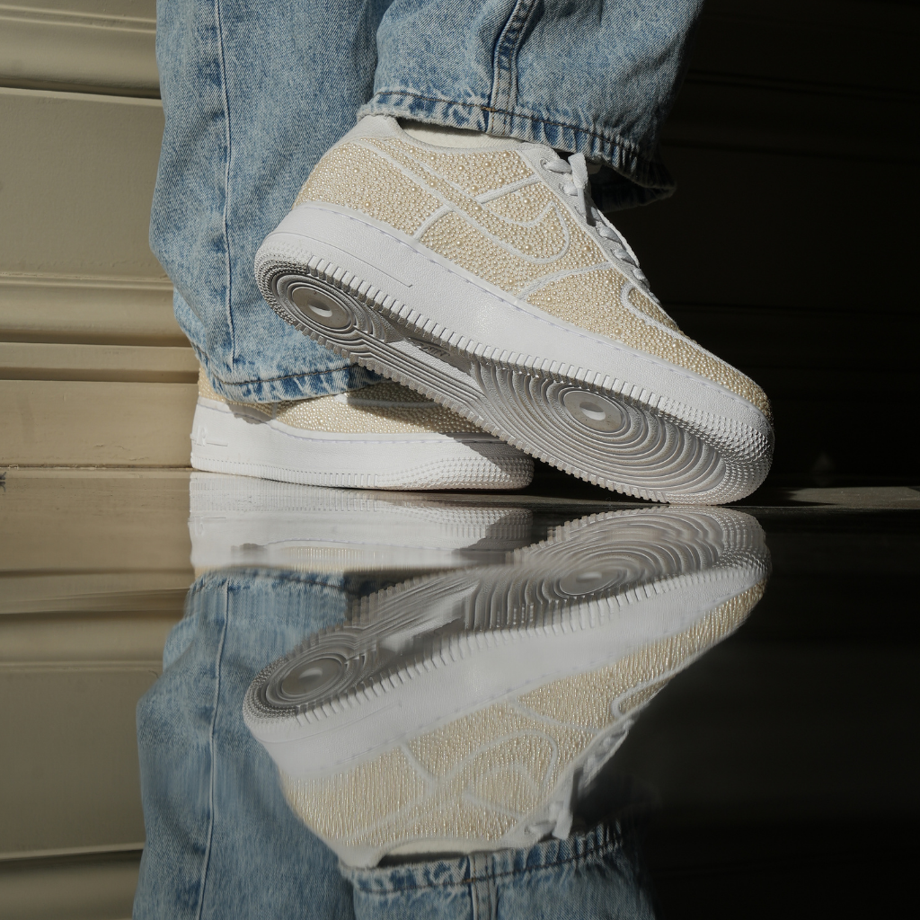Close-up of cream suede sneakers with white soles and jeans, streetwear shoe reflection