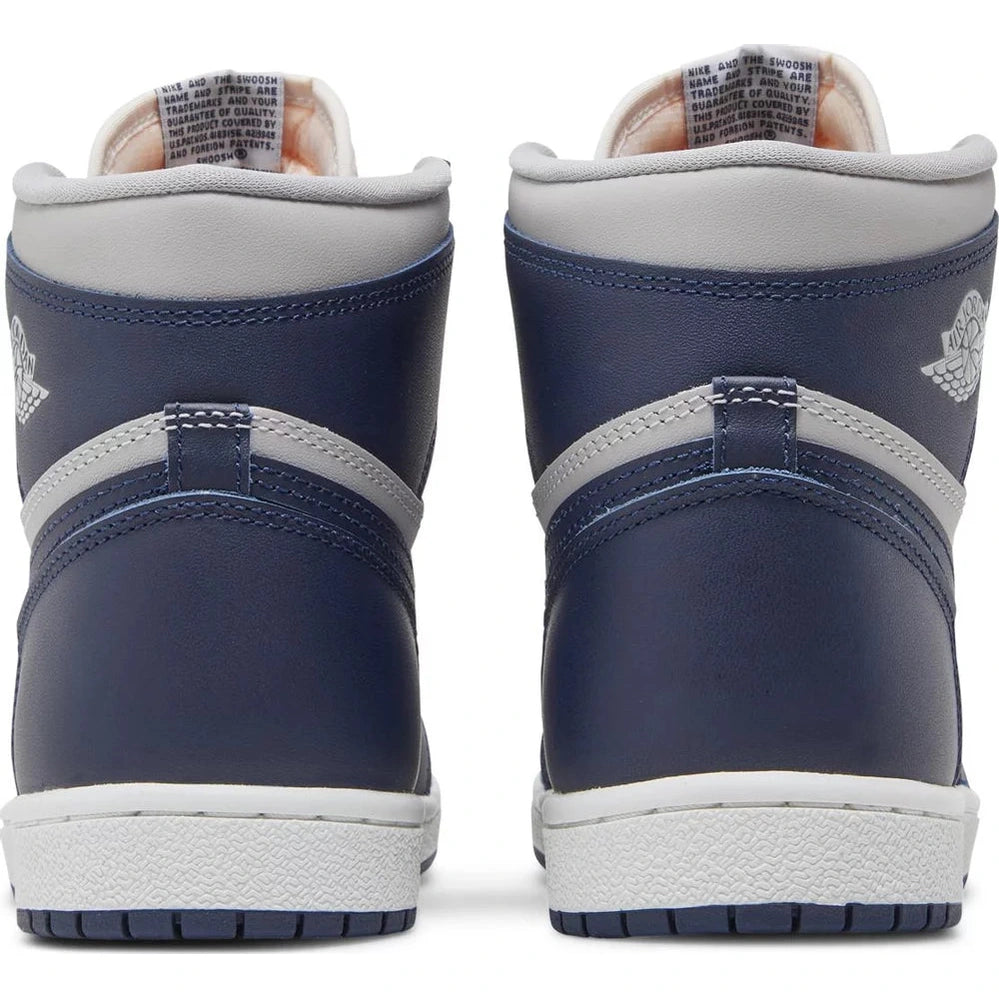 Rear view of navy blue and grey high-top sneakers with white soles, streetwear style.