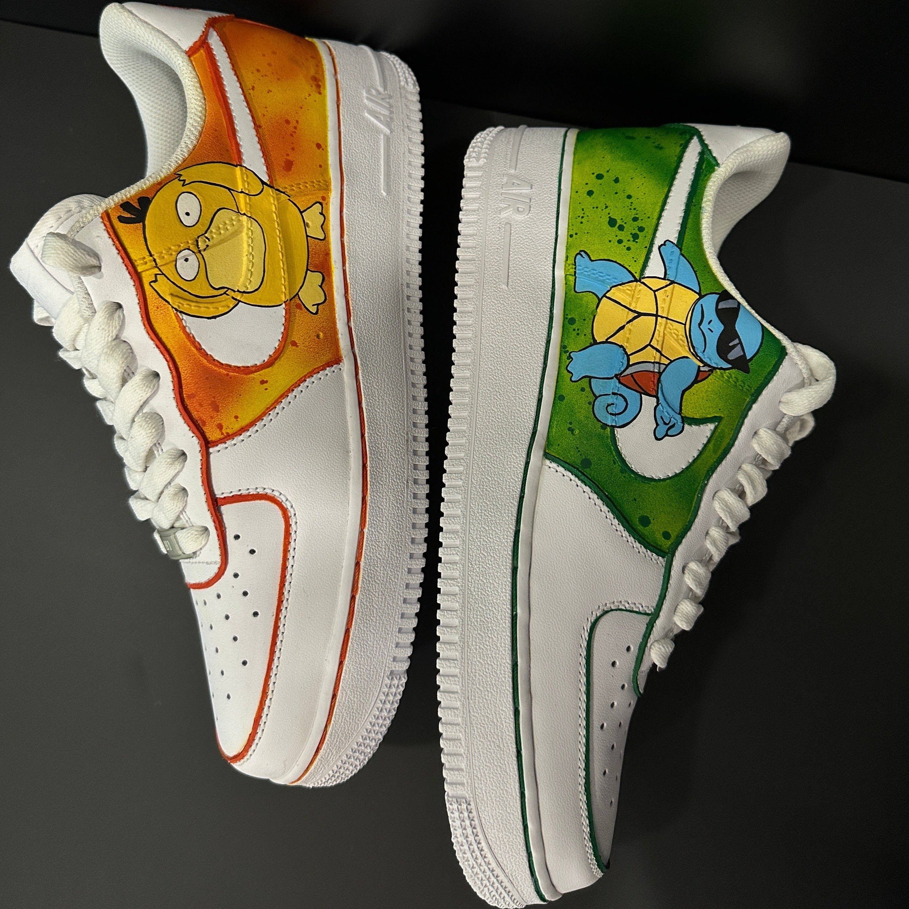Custom white sneakers featuring hand-painted Psyduck and Squirtle designs, orange and green accents