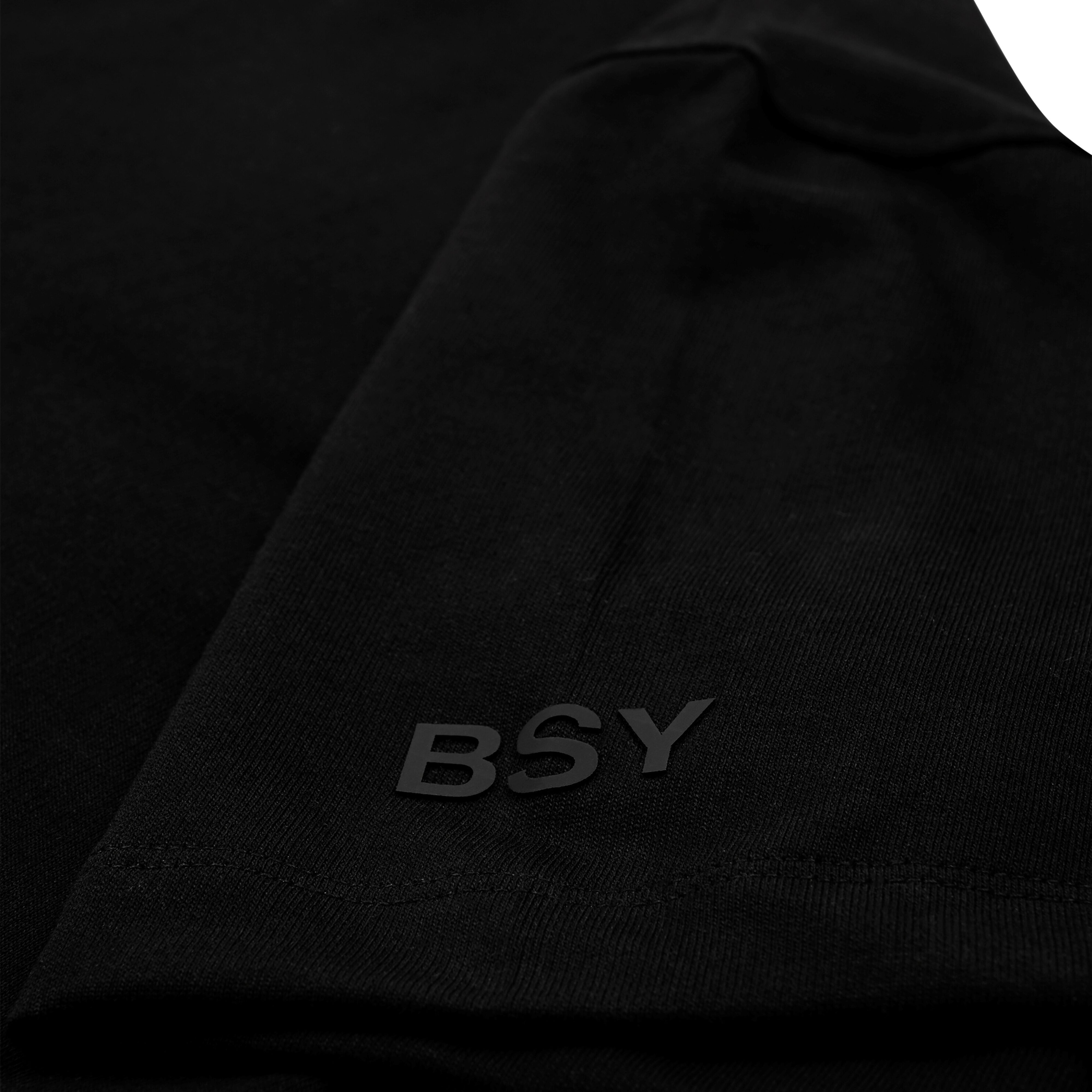Close-up of black streetwear t-shirt sleeve with raised BSY text detail