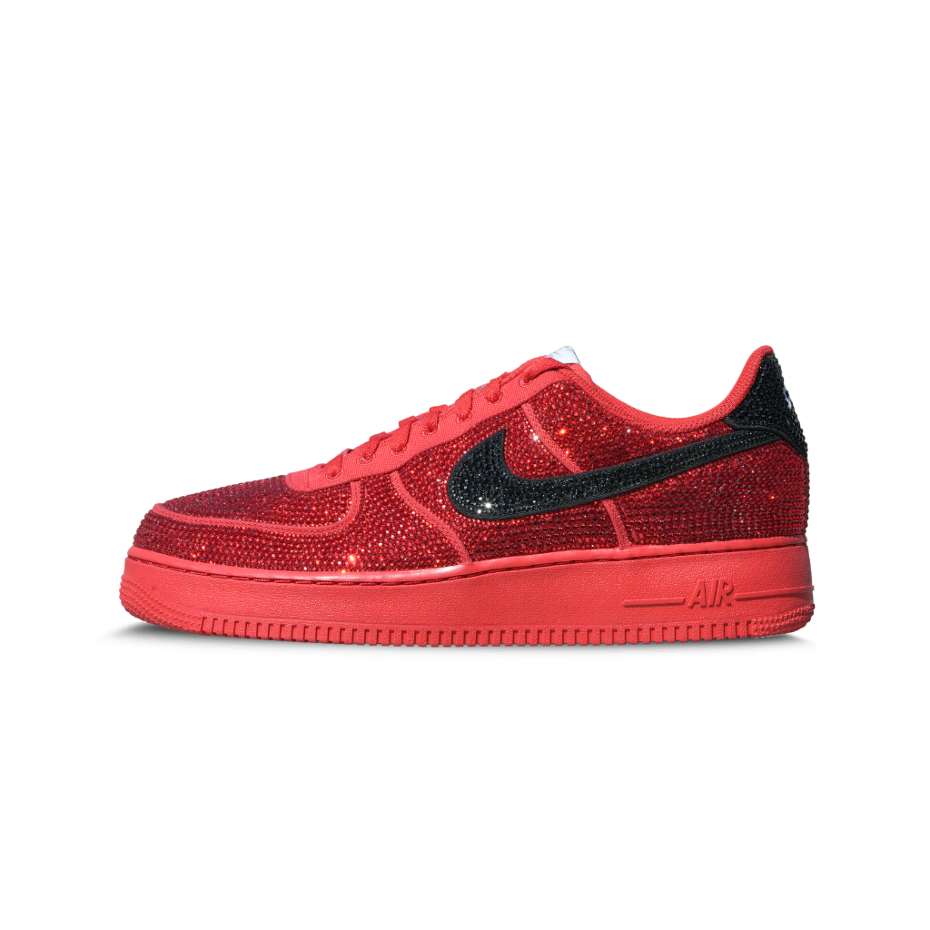 Red low-top sneaker covered in rhinestones with black swoosh, luxury streetwear footwear