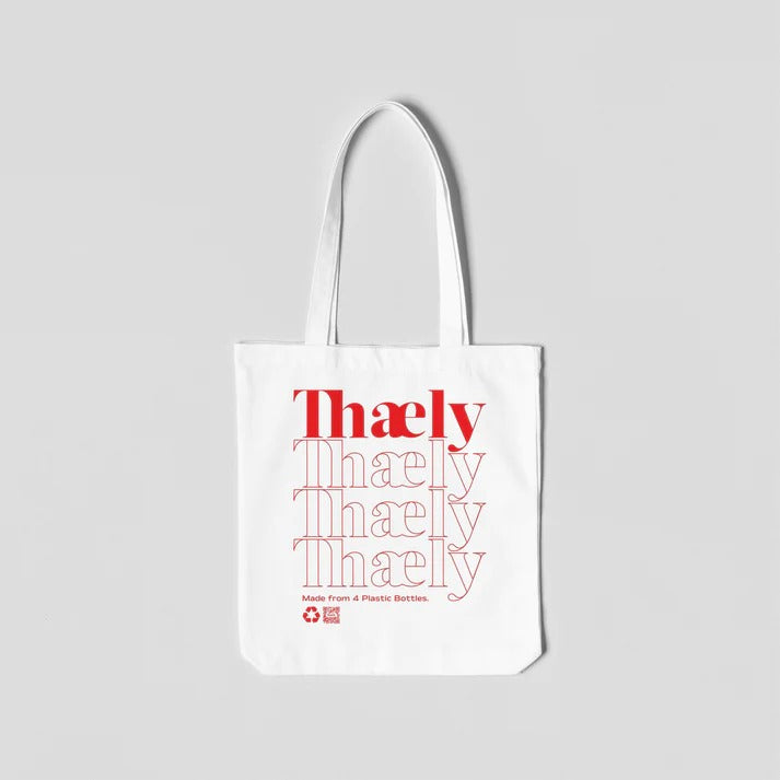 White tote bag with red 'Thaely' text, eco-friendly, made from 4 recycled plastic bottles.