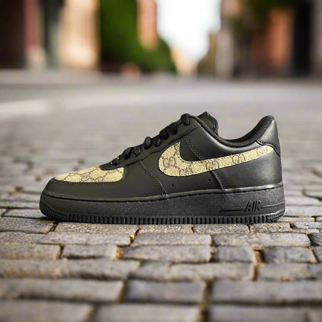 Black streetwear sneaker with gold patterned accents on cobblestone street