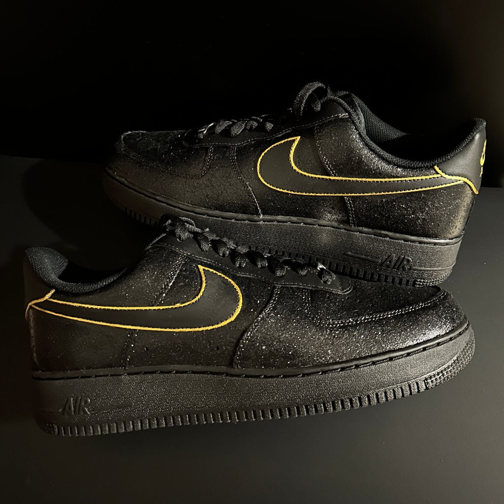 Black low-top Nike sneakers with yellow outlined swoosh, luxury streetwear shoes