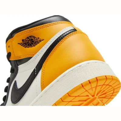 Close-up of yellow, white, and black high-top sneaker with logo and textured sole