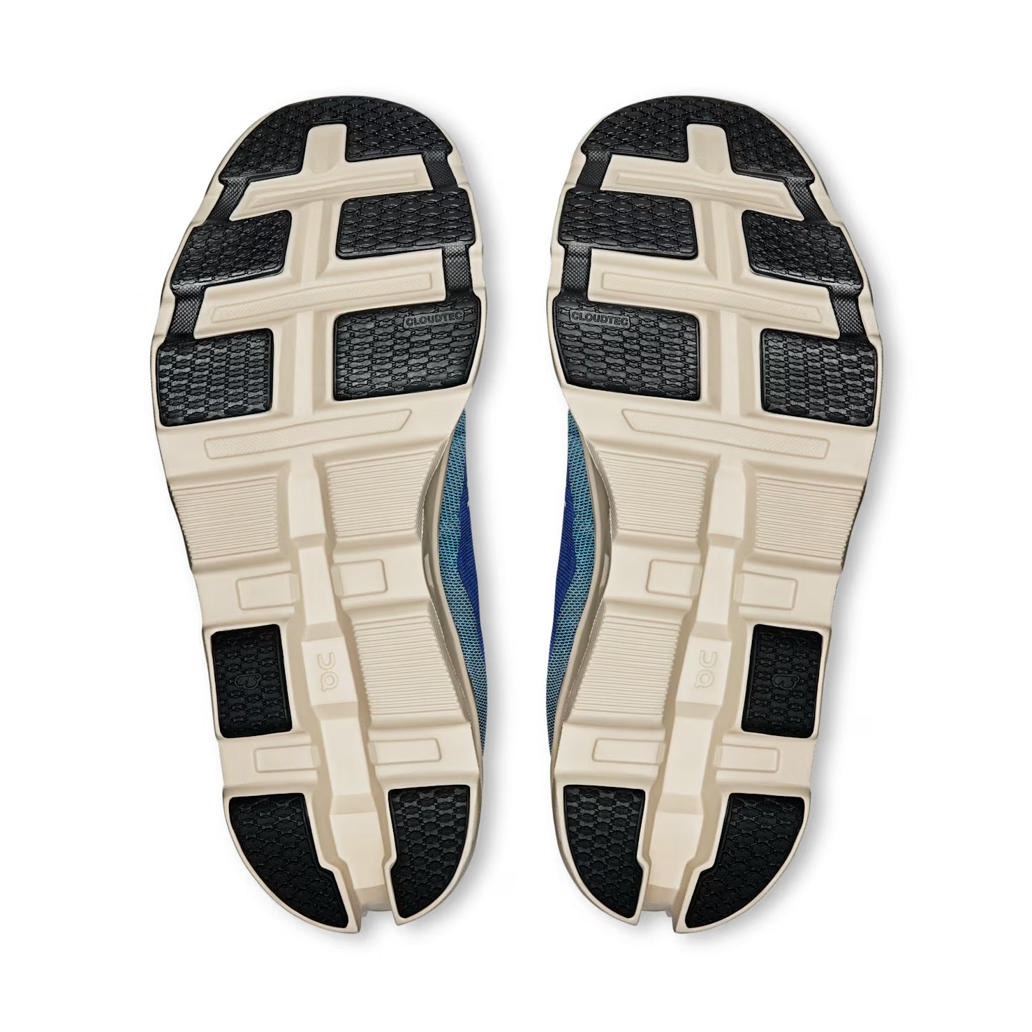 Pair of sneakers with beige and black textured outsoles, viewed from the bottom