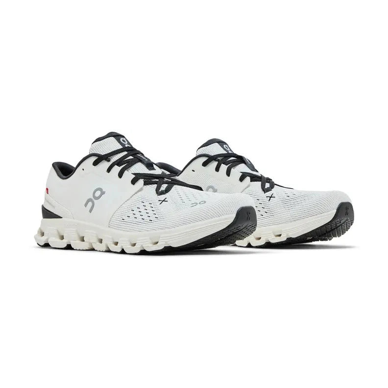 White mesh athletic sneakers with black laces and cushioned soles, side view