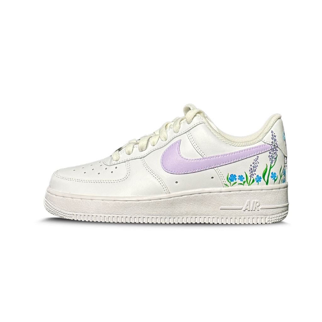White streetwear sneaker with lavender swoosh and floral side detailing on a white background
