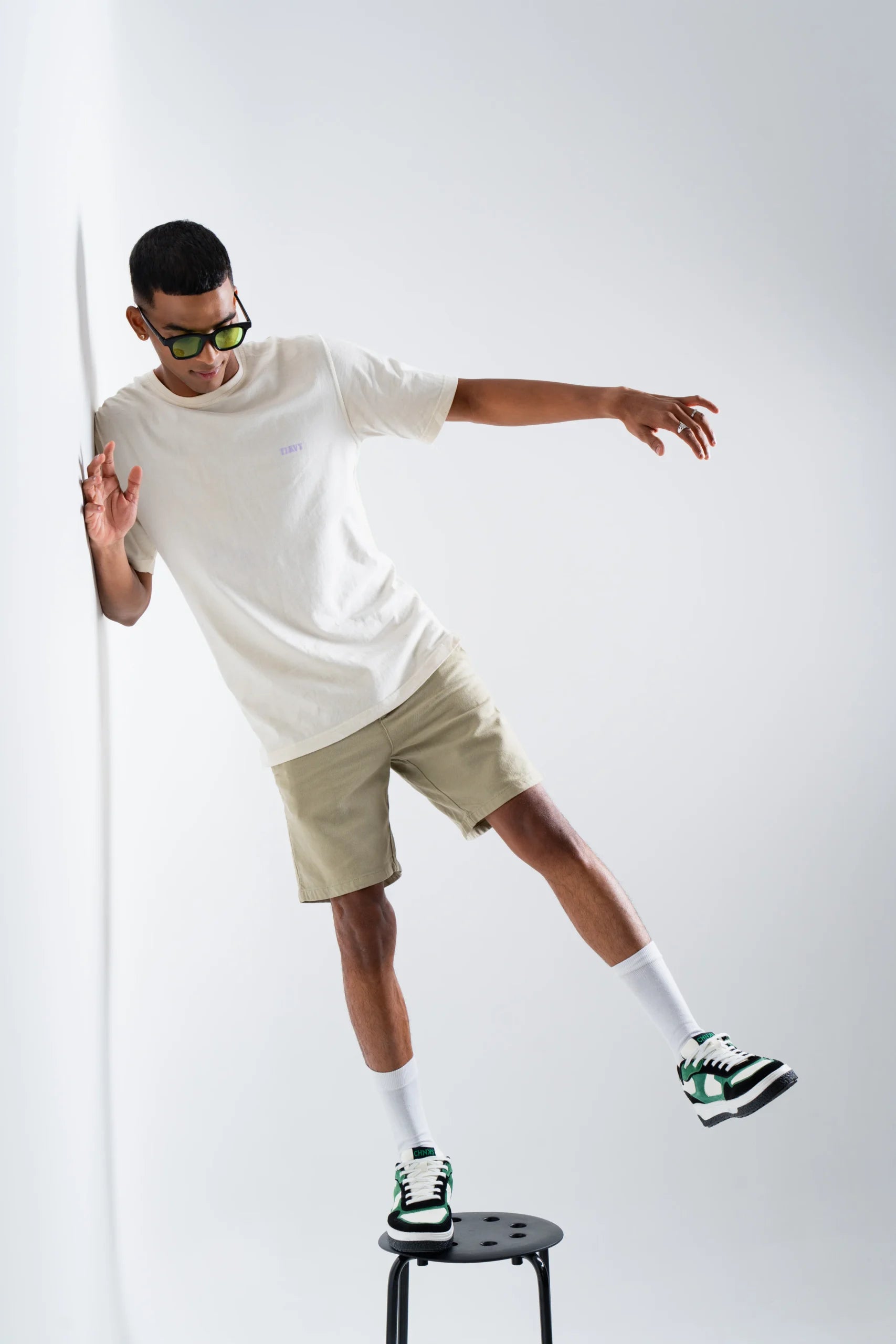 Model wearing Matrix CHNKS sneakers with white t-shirt and beige shorts – men’s green streetwear sneakers