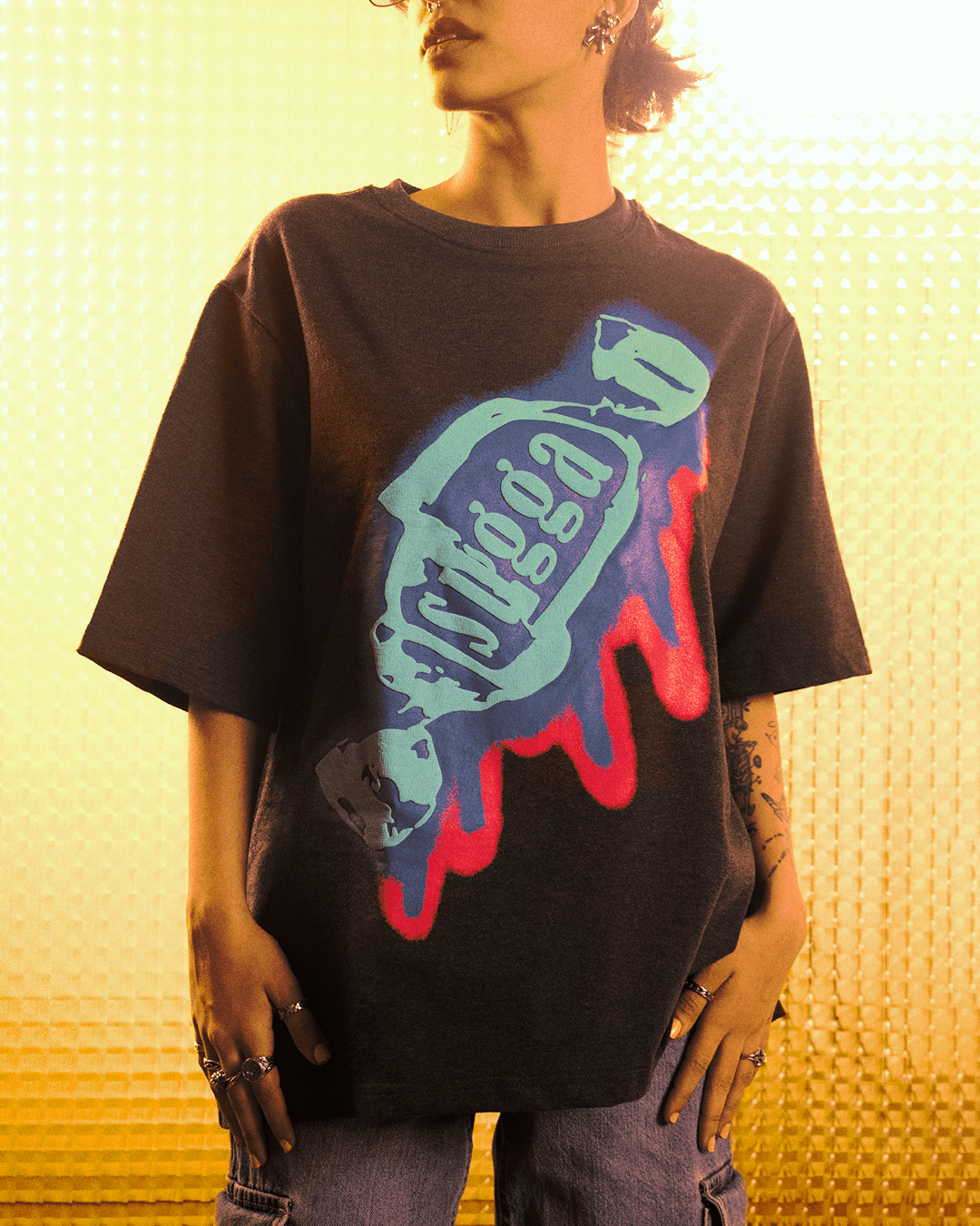 Woman wearing oversized black streetwear t-shirt with bold blue and red graphic print, casual style