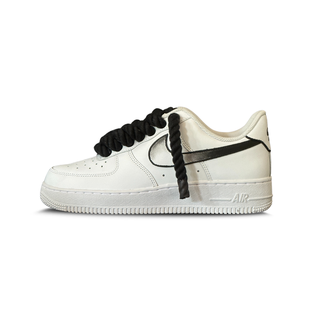 White low-top sneaker with thick black rope laces and black ombre swoosh design