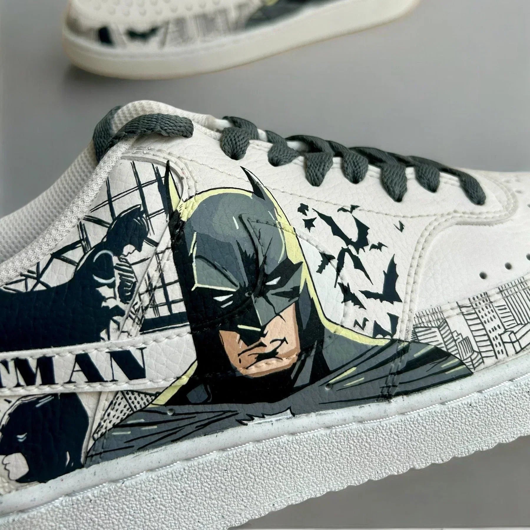White custom sneaker featuring Batman comic art and black bats on the side panel.