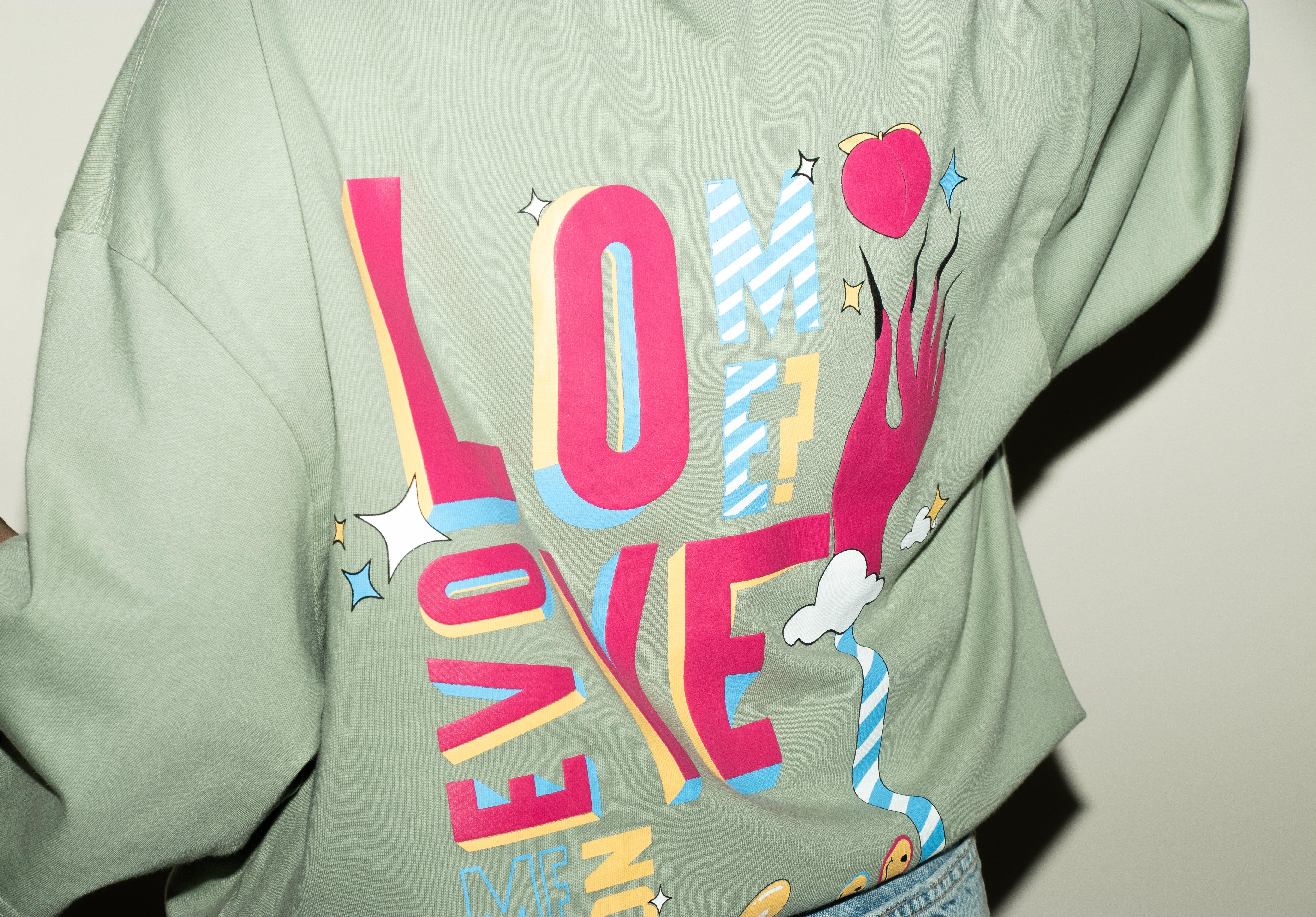 Green streetwear t-shirt with colorful graphic print, large letters and playful illustrations on back