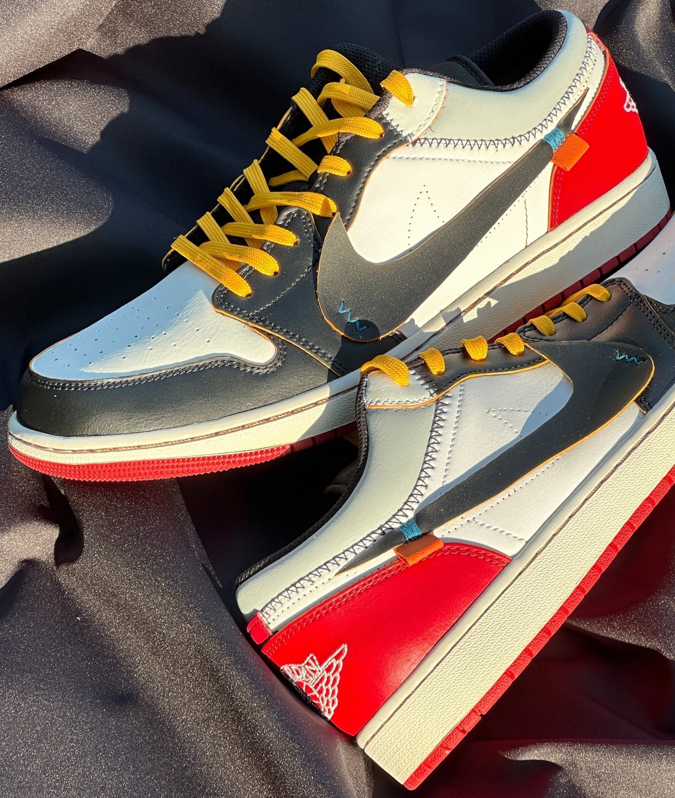 Colorful low-top streetwear sneakers with yellow laces, red heel, and black swoosh on fabric