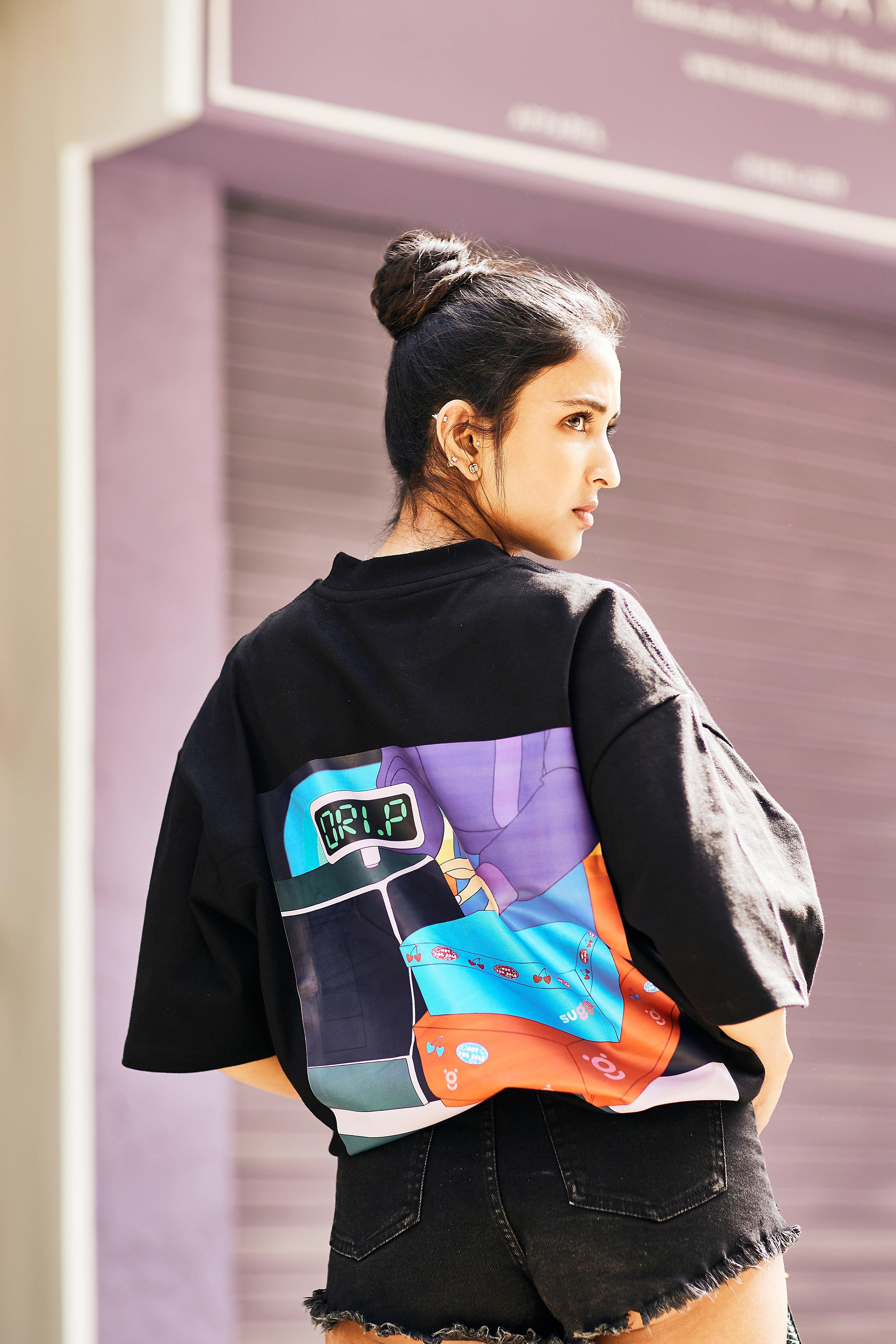 Woman wearing black streetwear t-shirt with colorful graphic print and black denim shorts